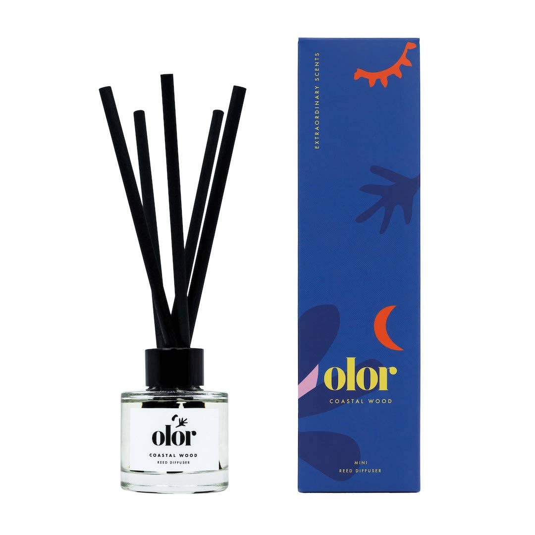 Olor diffuser bottle with black reeds and blue packaging on a white background