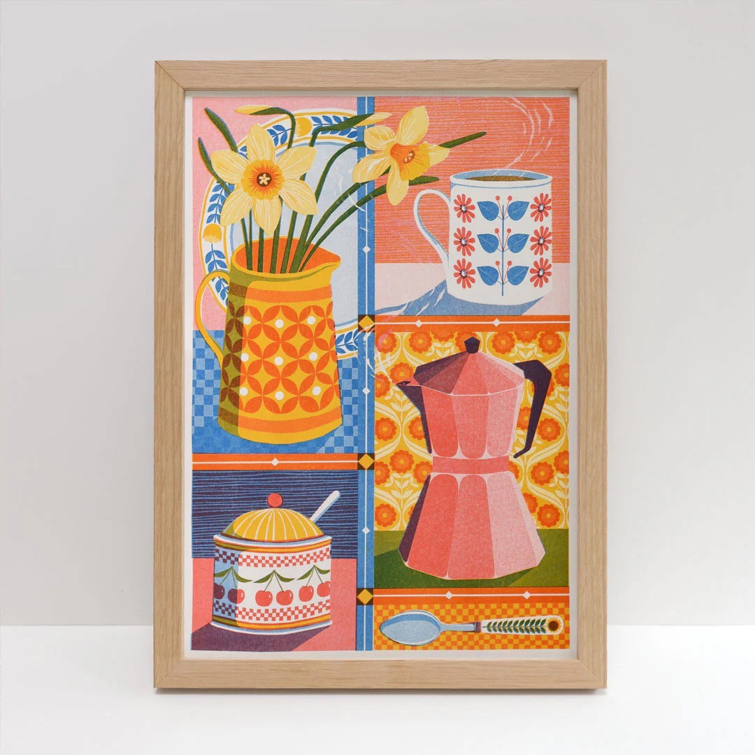 Framed artwork with colourful design of a pitcher, flowers, and kitchen items on a white background.