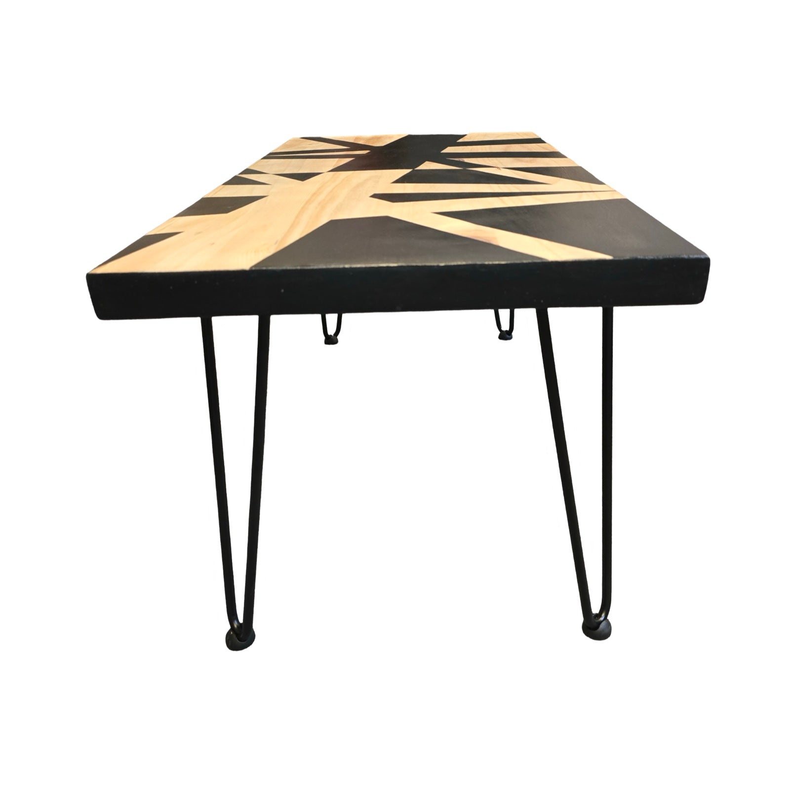 An upcycled coffee table with black hairpin legs and a bold black geometric design on a wooden surface, set against a white background.