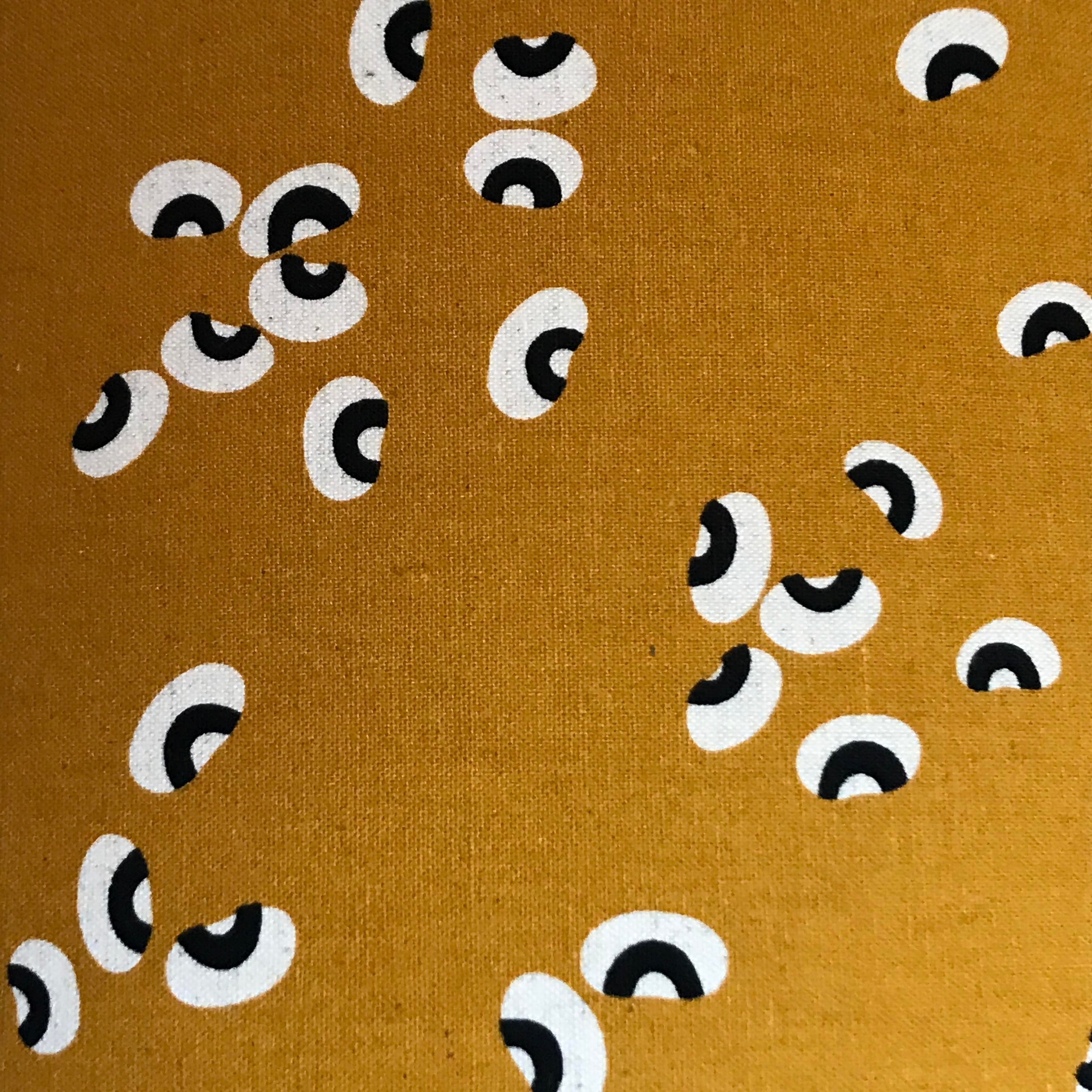 Mustard fabric with a black and white beans pattern