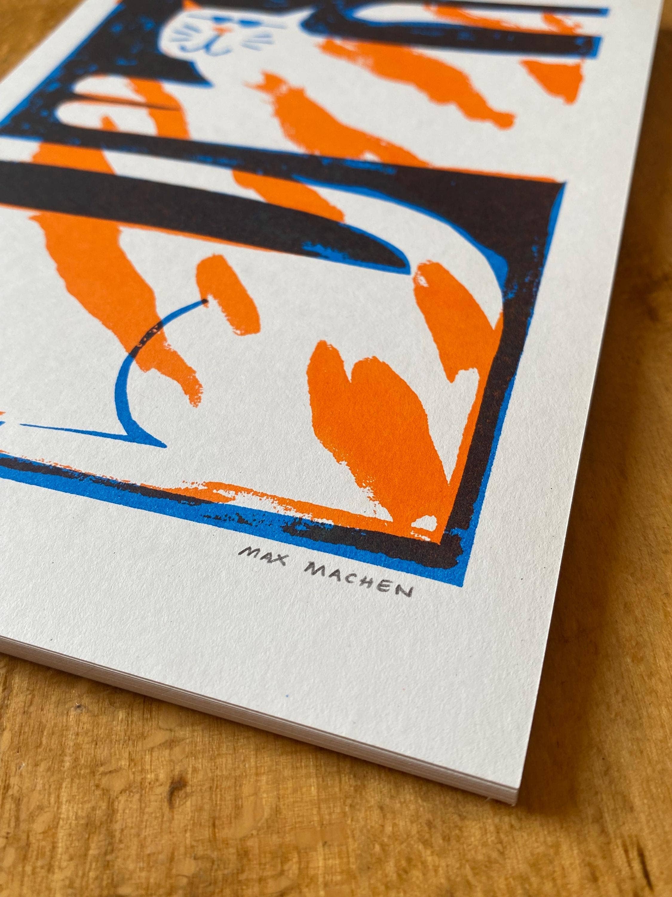 Two-colour risograph print featuring a ginger and white cat, against a black background.