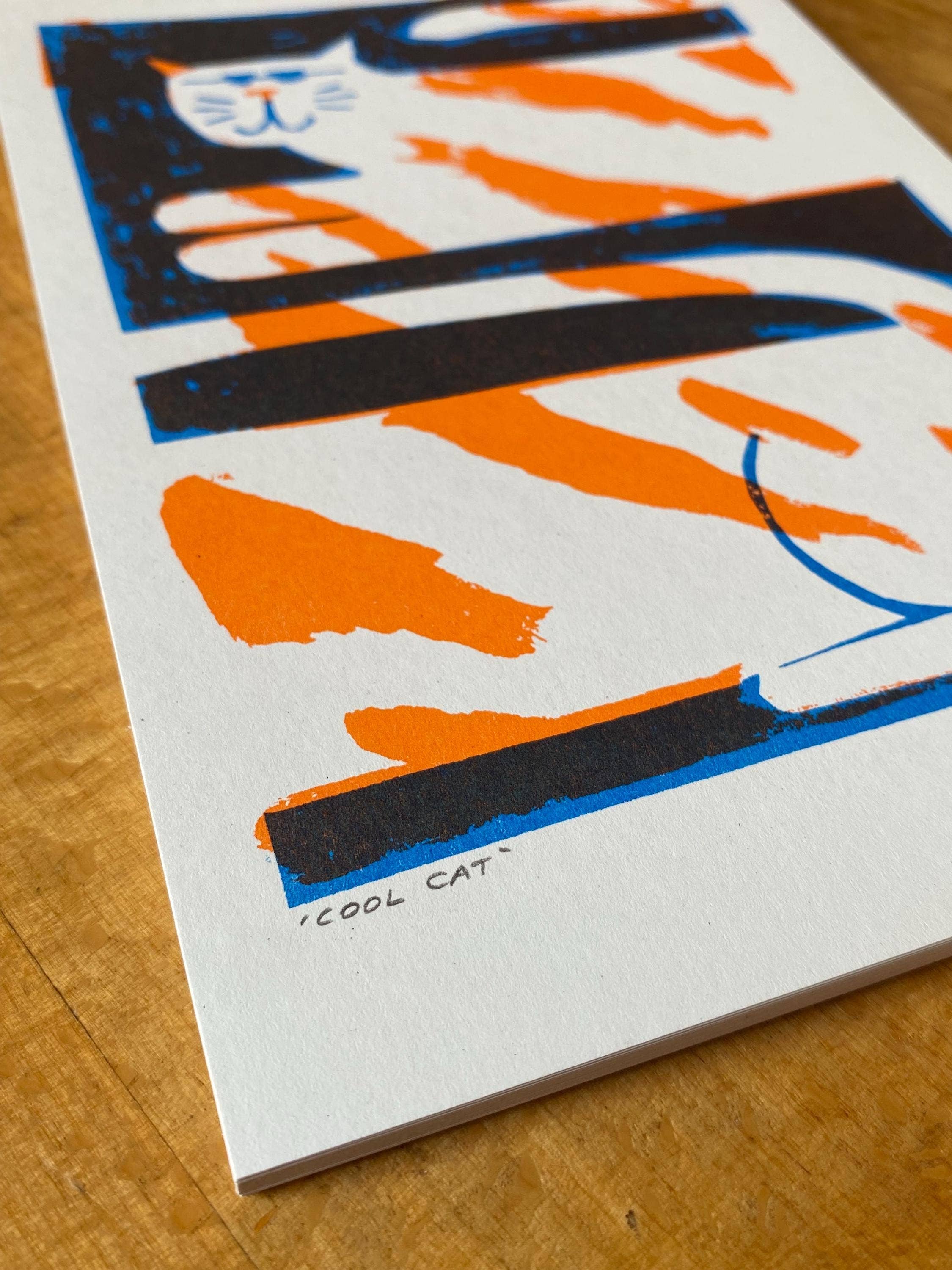 Two-colour risograph print featuring a ginger and white cat, against a black background.