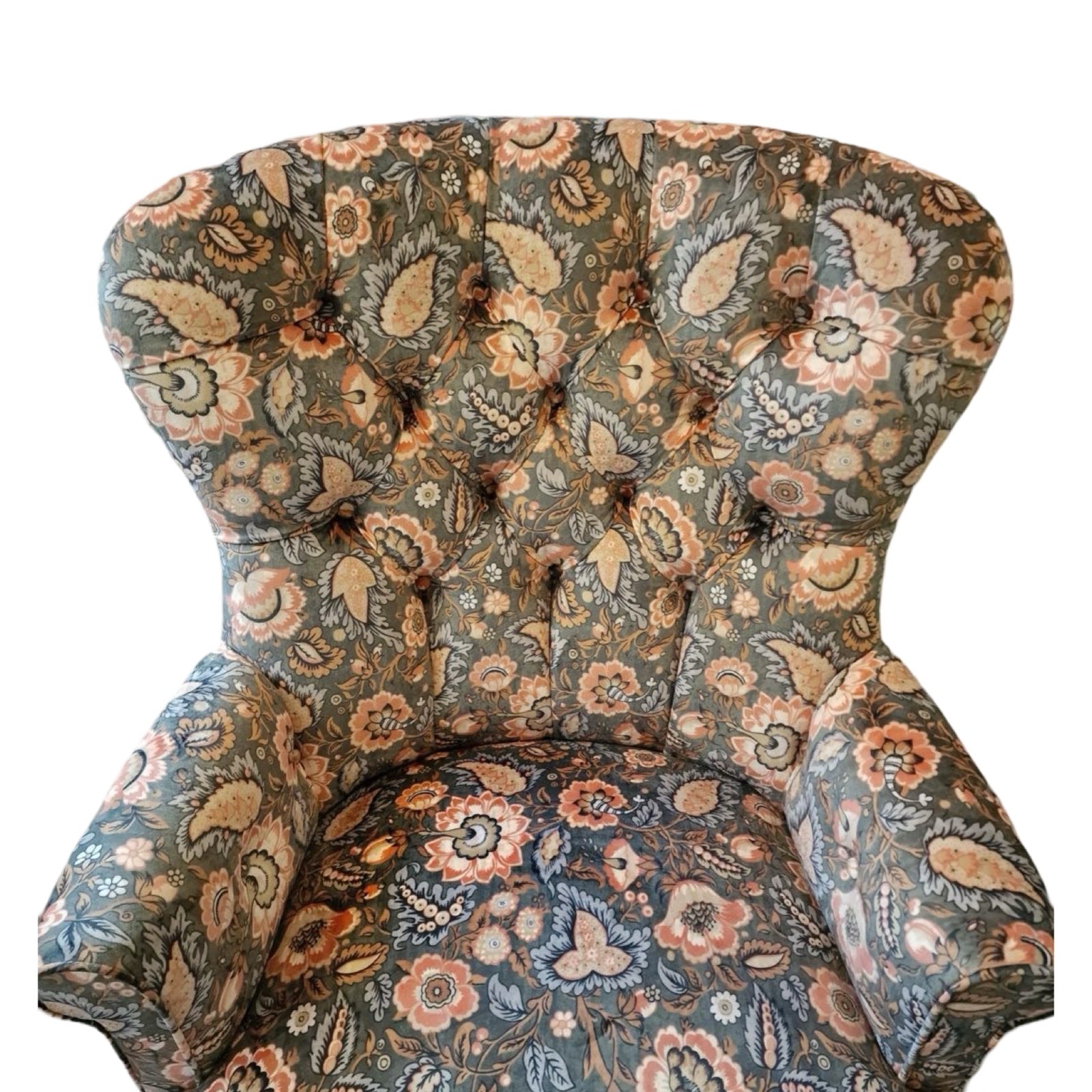 A luxurious armchair upholstered in light green/grey velvet with a floral pattern of coral flowers and pale blue leaves, featuring a button-back design, cream binding, and mahogany legs with gold castors.