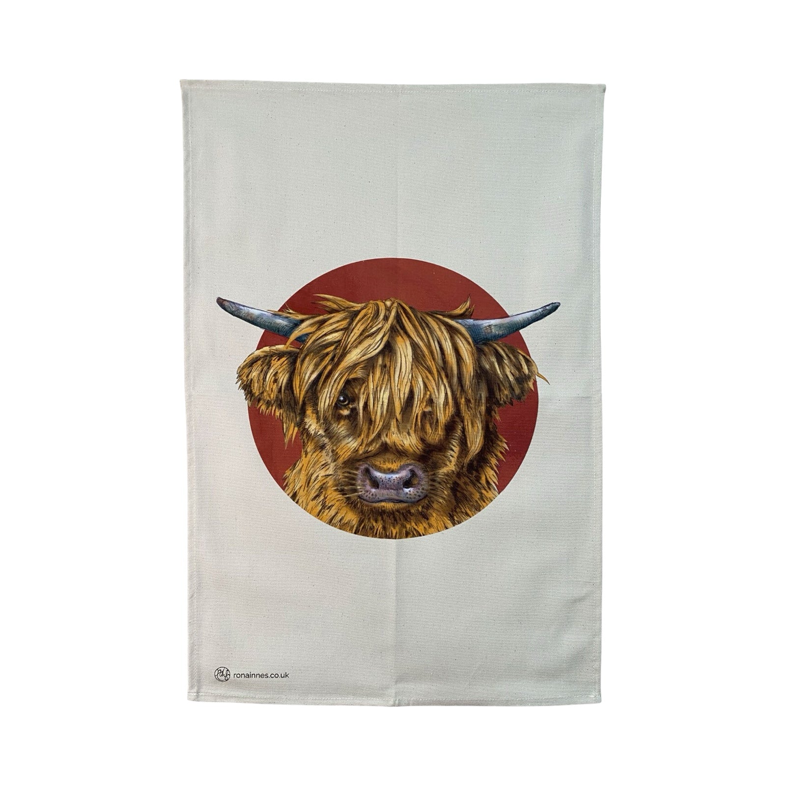 A tea towel featuring an illustration of the face of a highland cow, in a deep red circle against an off-white background. 