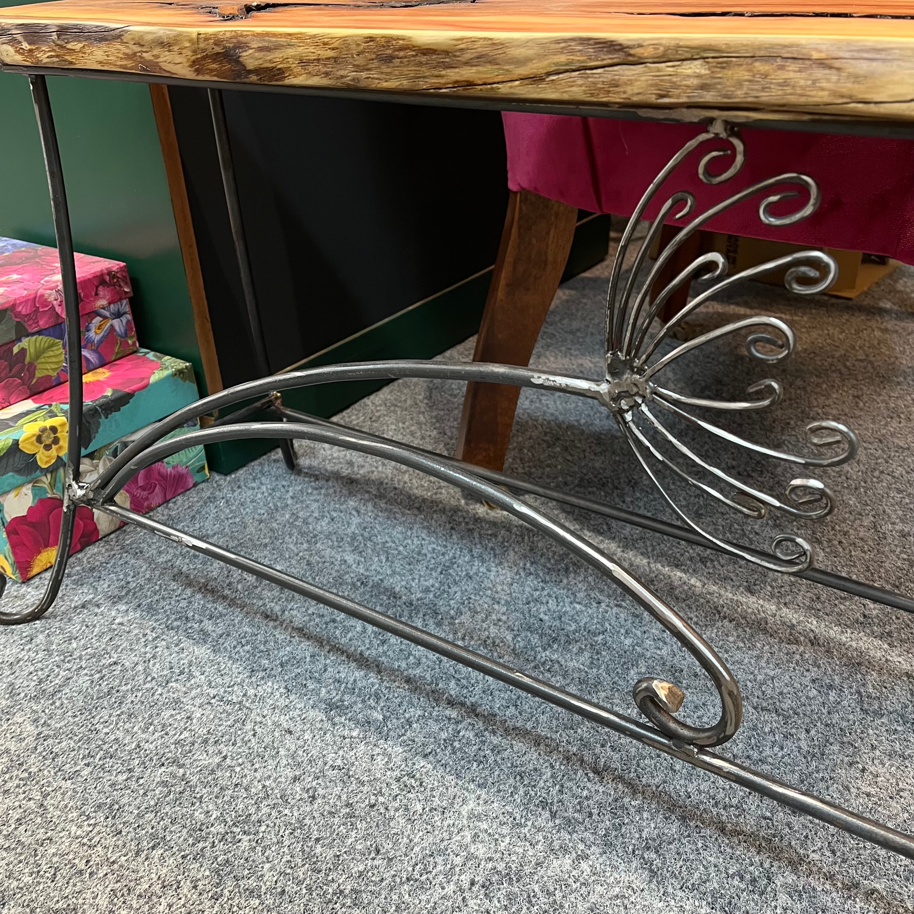 A handmade table/bench with an yew wooden top and a galvanised steel frame with a cow parsley design. Suitable for indoor or outdoor use. (Galvanised steel will dull as it weathers, but it won't rust).