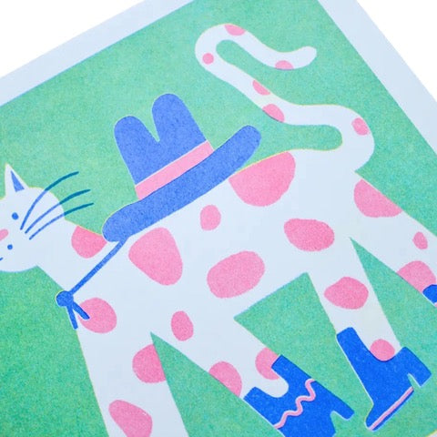 Art print featuring a white cat with pink spots wearing blue cowboy boots and a blue cowboy hat against a green background.
