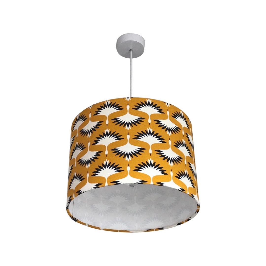 drum lampshade covered in mustard baby needlecord fabric featuring flying cranes in black and white.