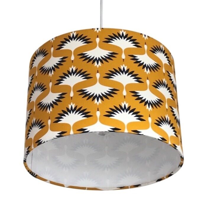 drum lampshade covered in mustard baby needlecord fabric featuring flying cranes in black and white.