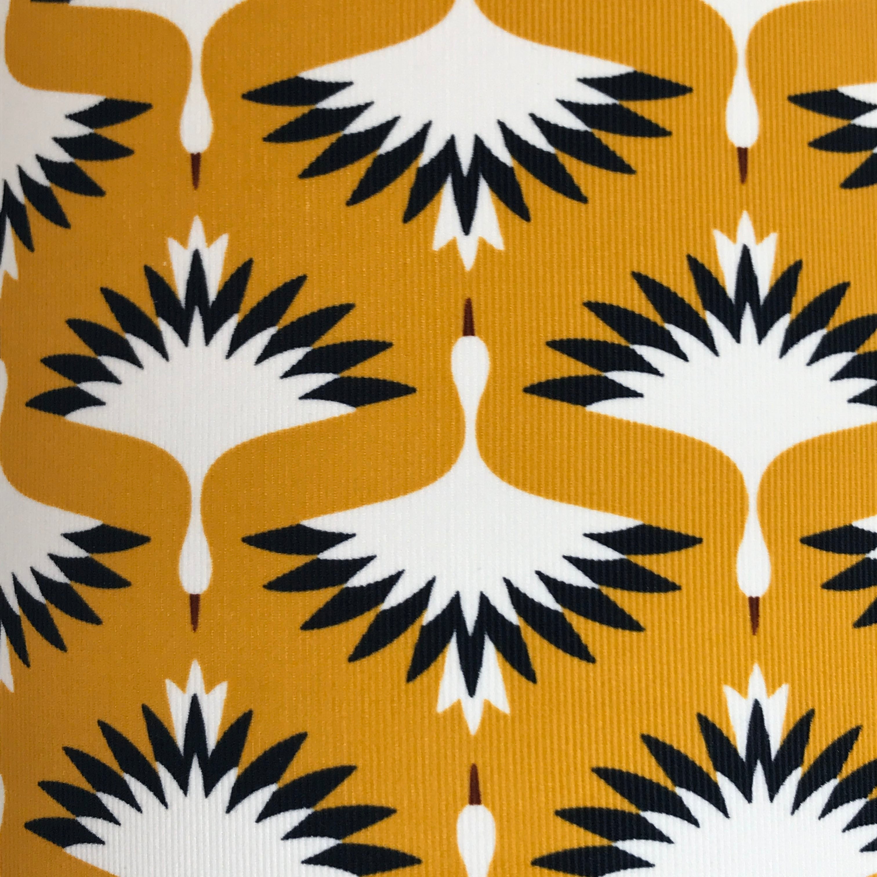 mustard fabric with black and white cranes (birds).