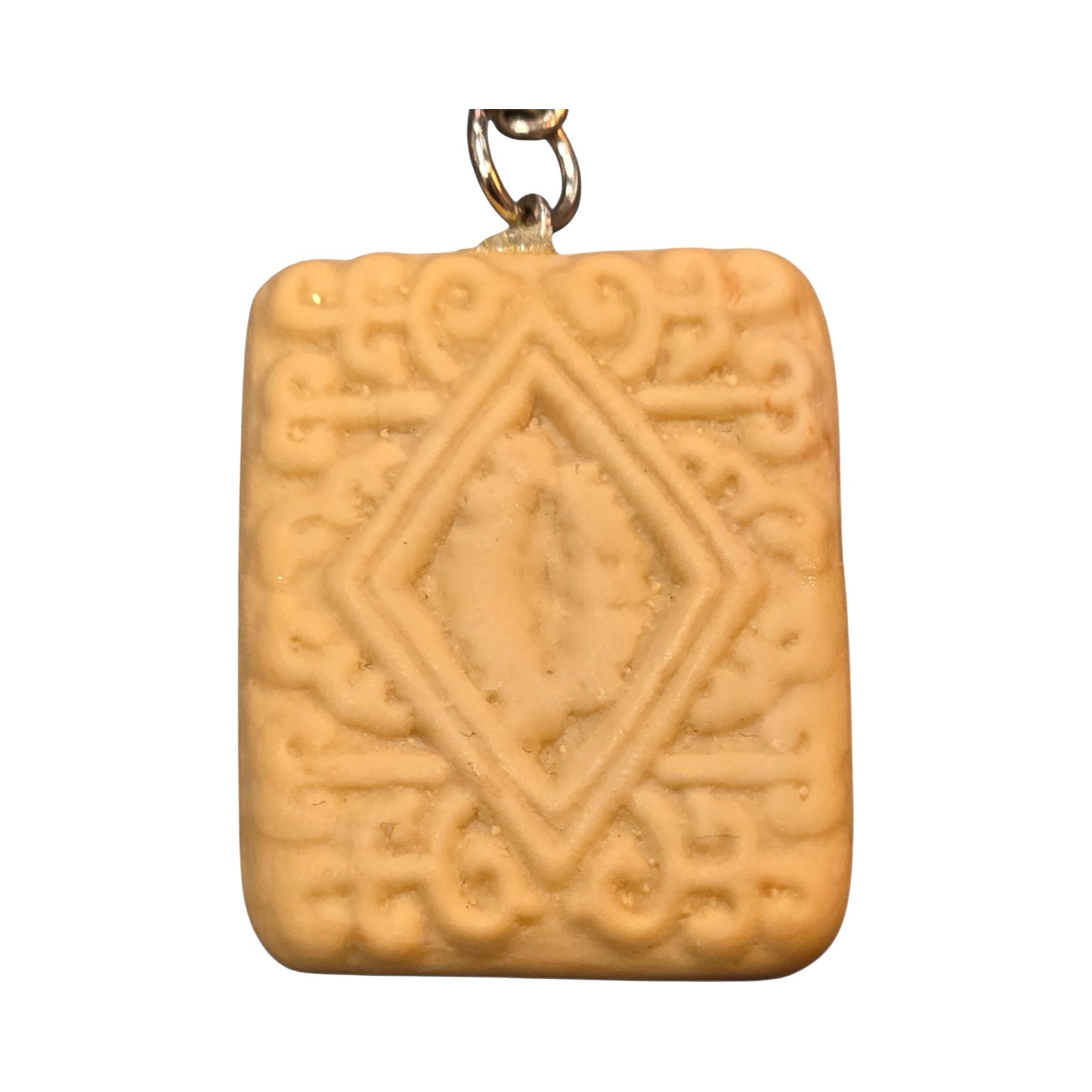 A fun keyring in the shape of a custard cream biscuit, made from polymer clay.