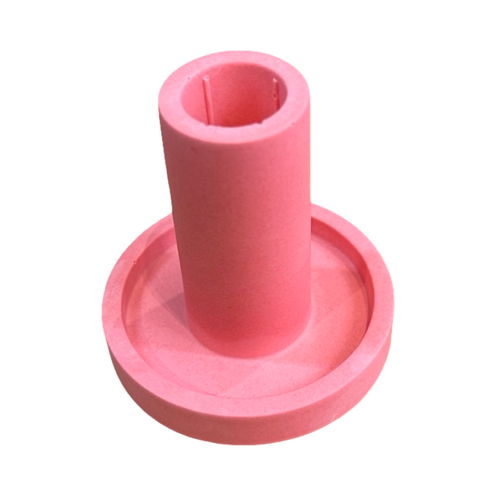 A pink cylindrical dinner candle holder with a lip around the bottom to catch any drips.