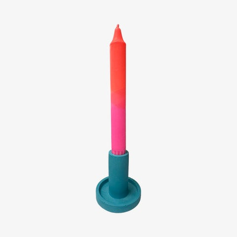 A cylindrical dinner candle holder with a lip around the bottom to catch any drips holding a blue dinner candle.