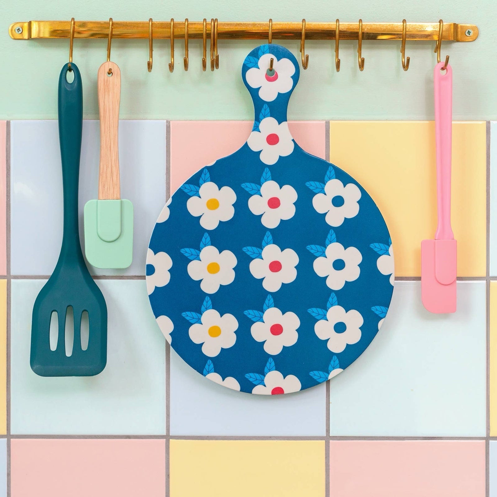 This blue melamine chopping board features a retro floral design and a handy hanging hole.