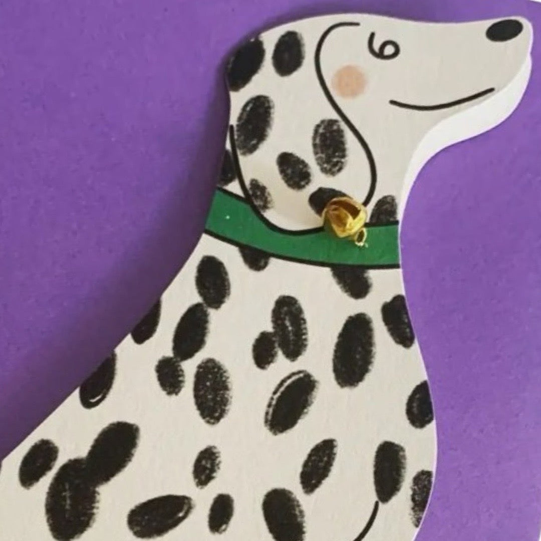 A black and white spotty Dalmatian shaped card with a green collar and a gold bell.