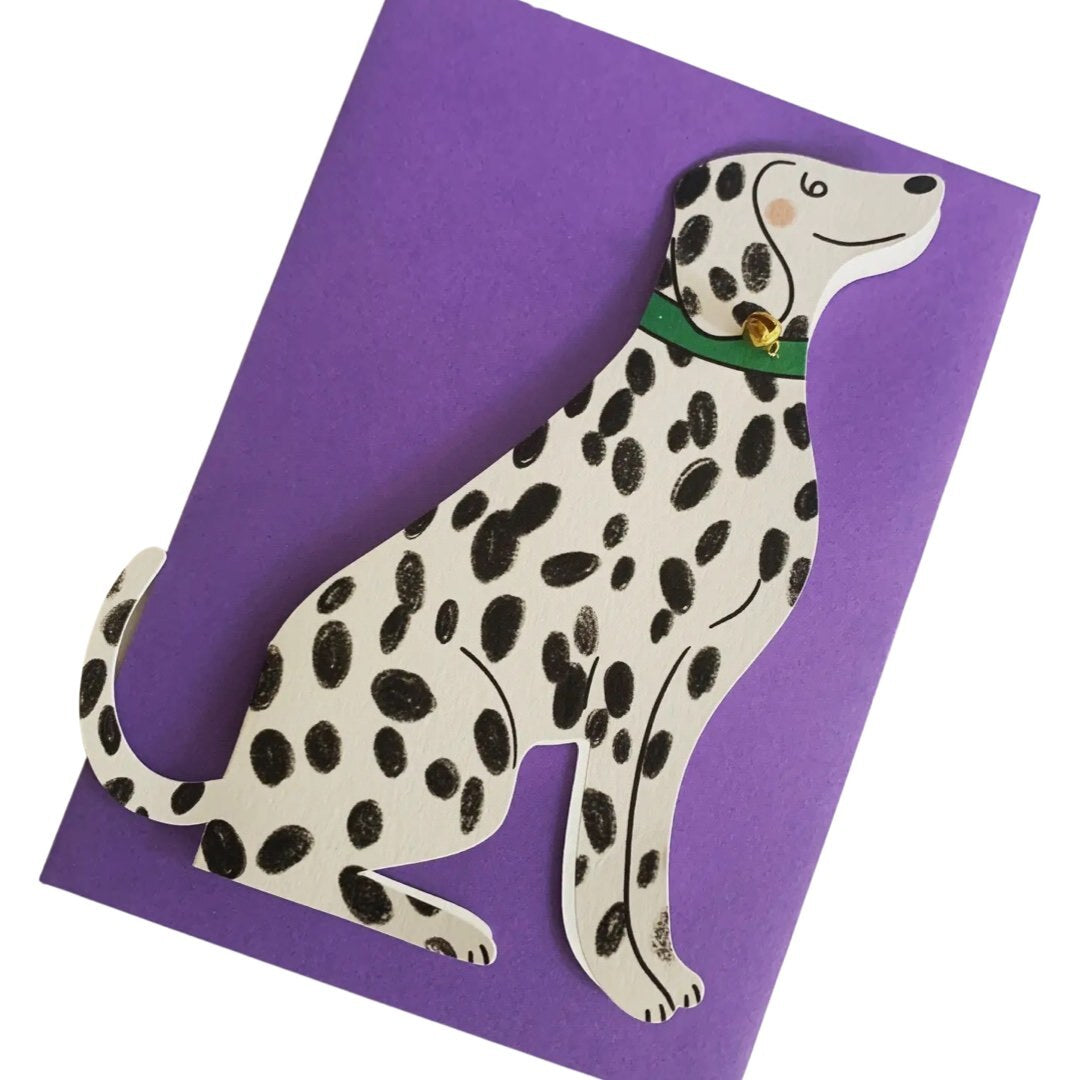 A black and white spotty Dalmatian shaped card with a green collar and a gold bell.