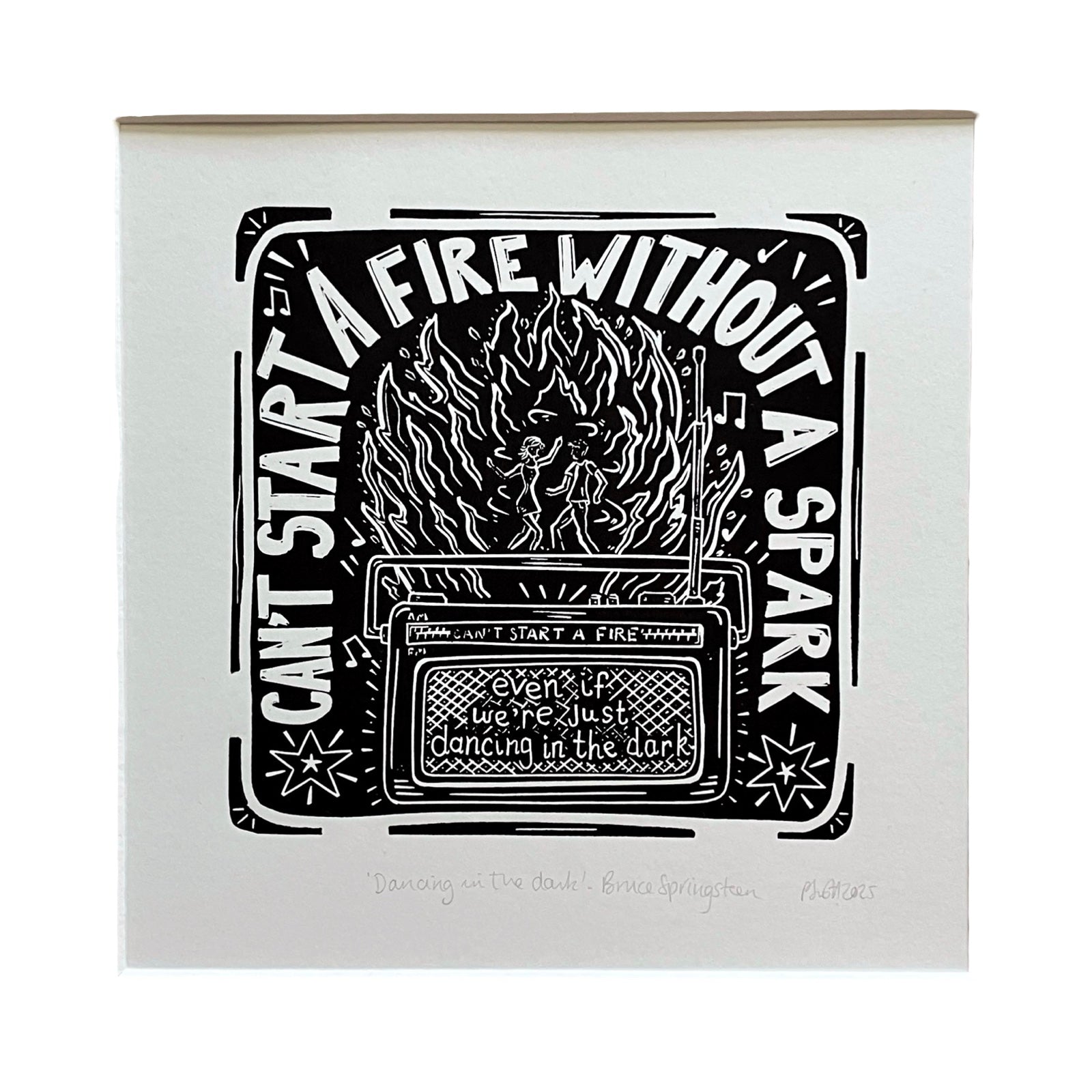 This black and white linocut print features a getoblaster sitting infront of a bonfire with the lyrics 'can't start a fire without a spark' from the song Dancing in the Dark by Bruce Springsteen.