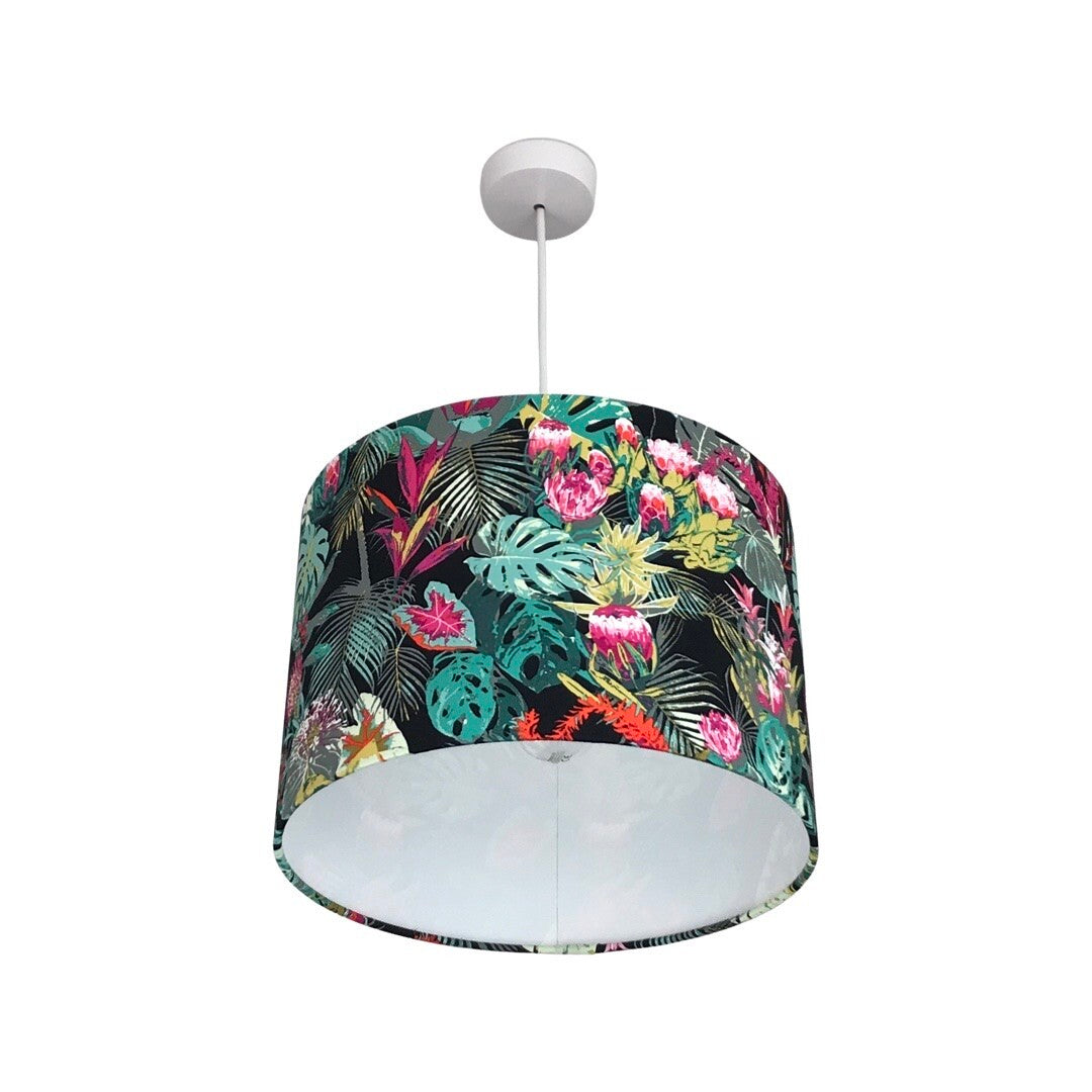 Drum lampshade covered in dark cotton fabric with bright tropical flowers and leaves