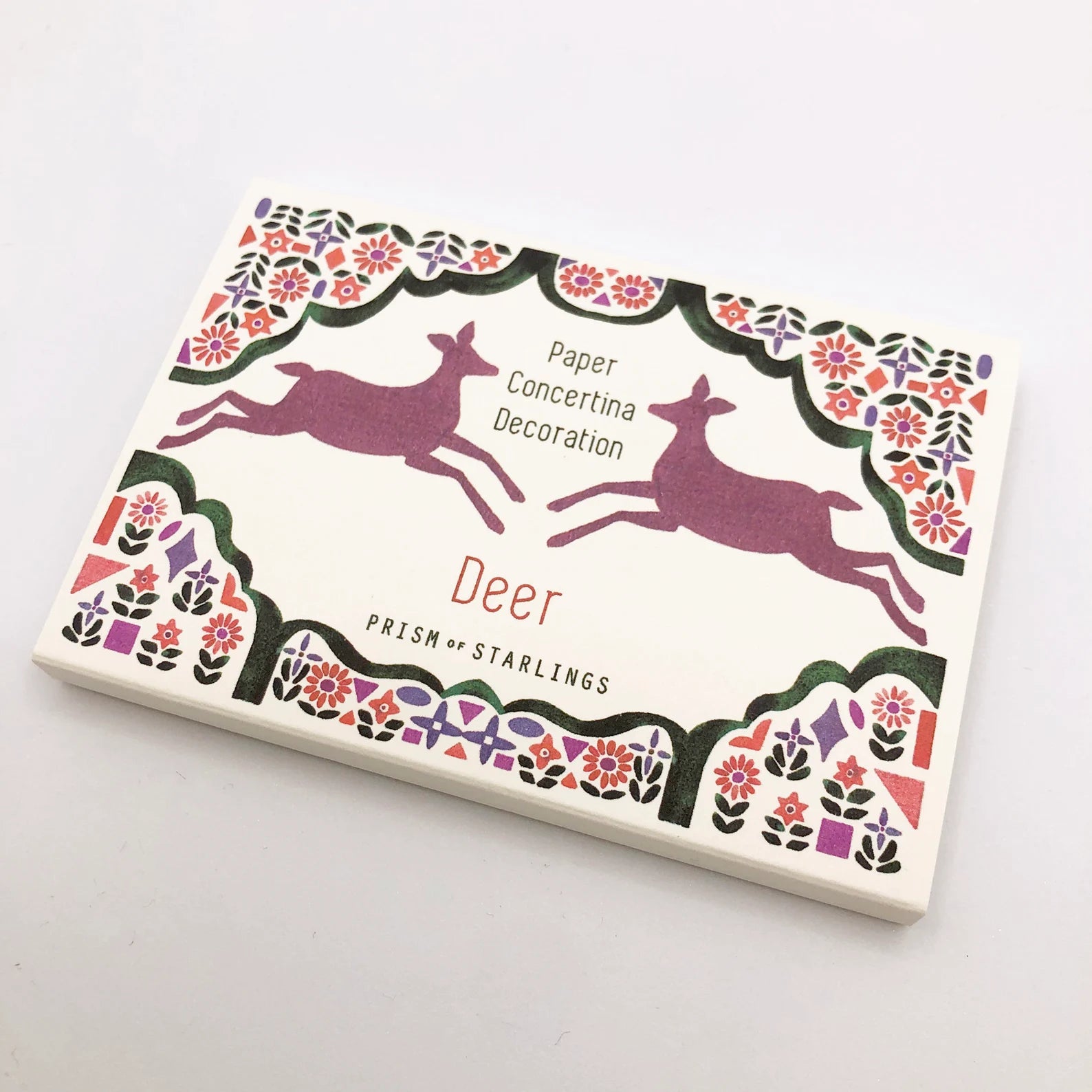 Decorative paper concertina with deer illustrations on a white background.