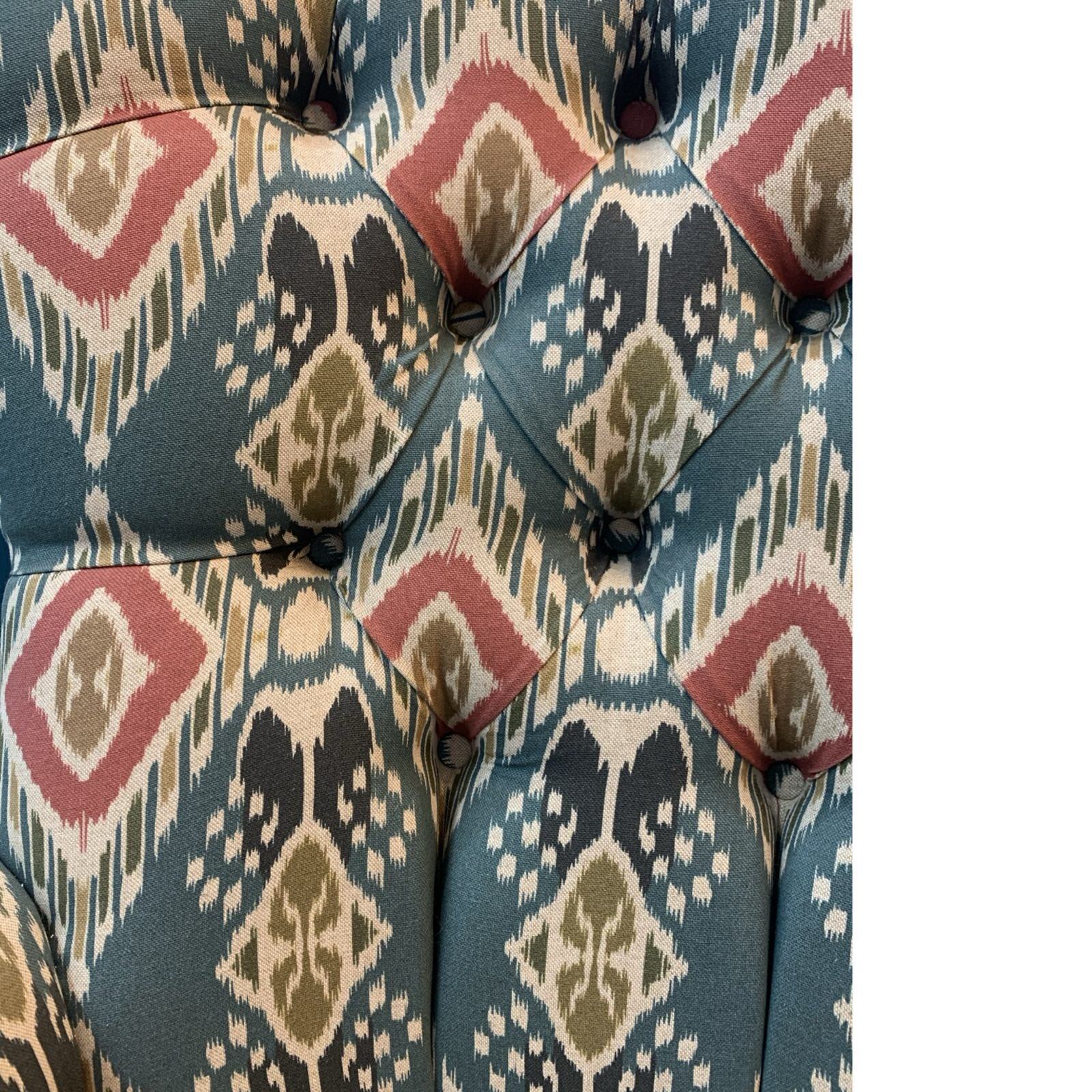 A hand-crafted armchair in blue linen with a red and mustard diamond design. 