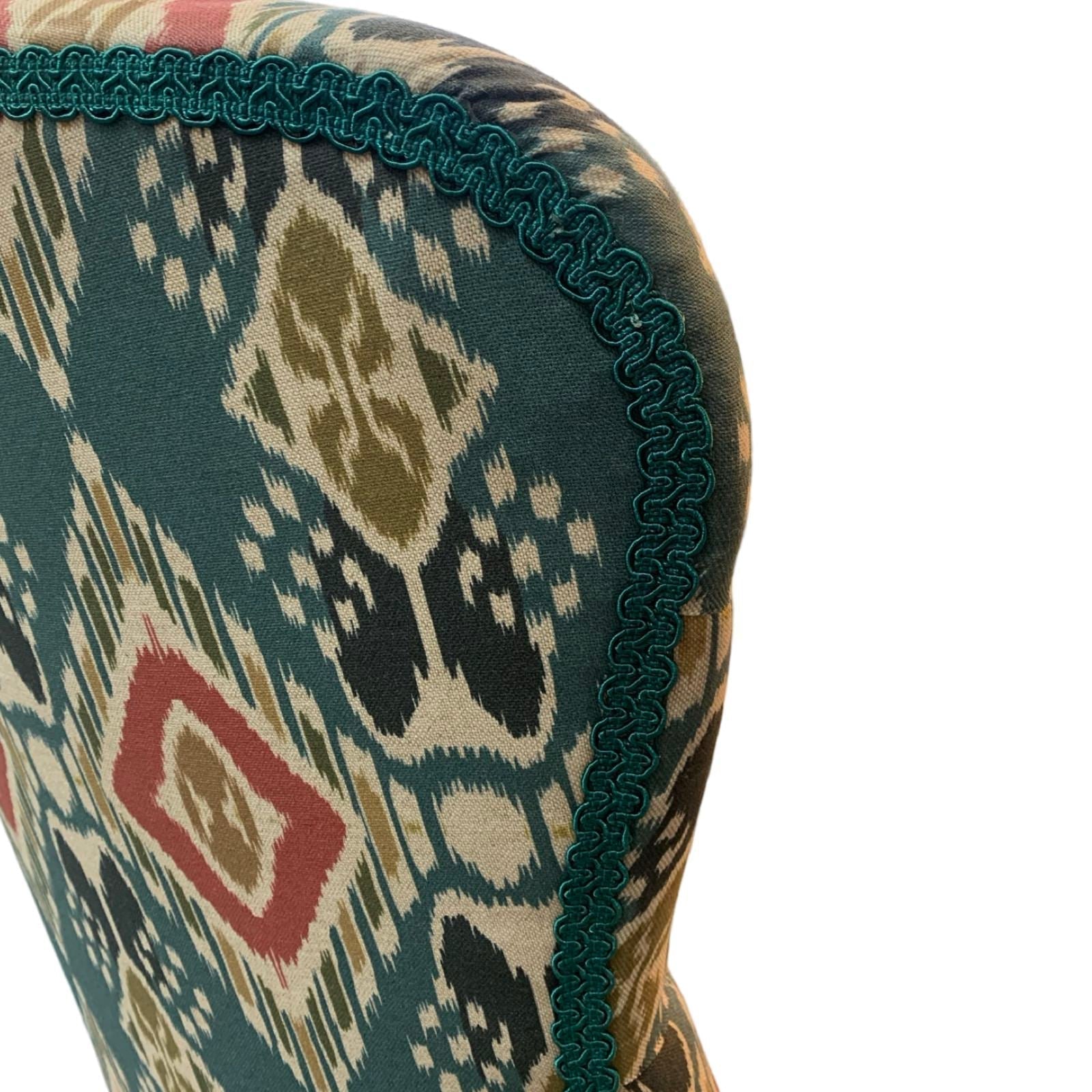 A hand-crafted armchair in blue linen with a red and mustard diamond design. 