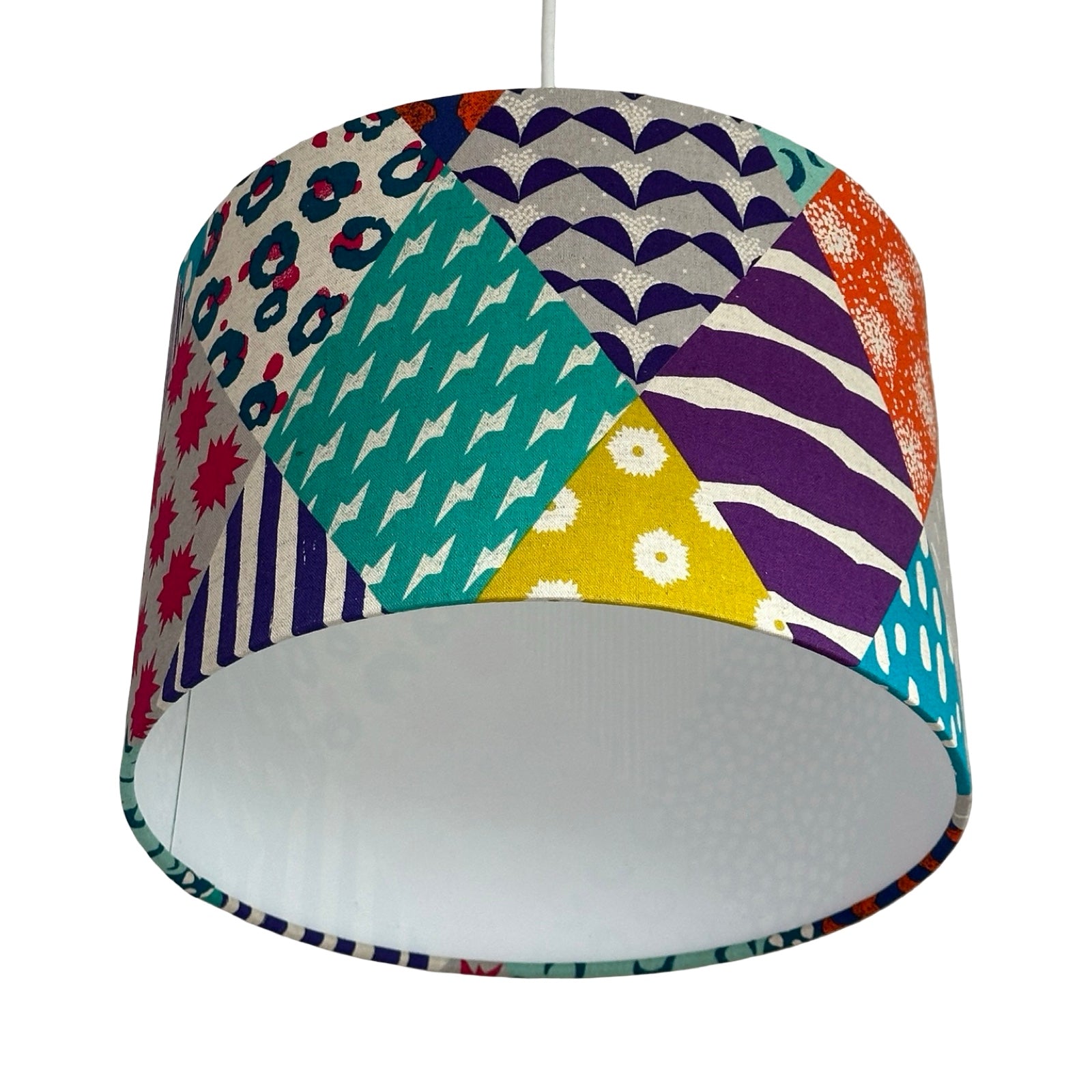Colourful geometric patterned lampshade on a white background.