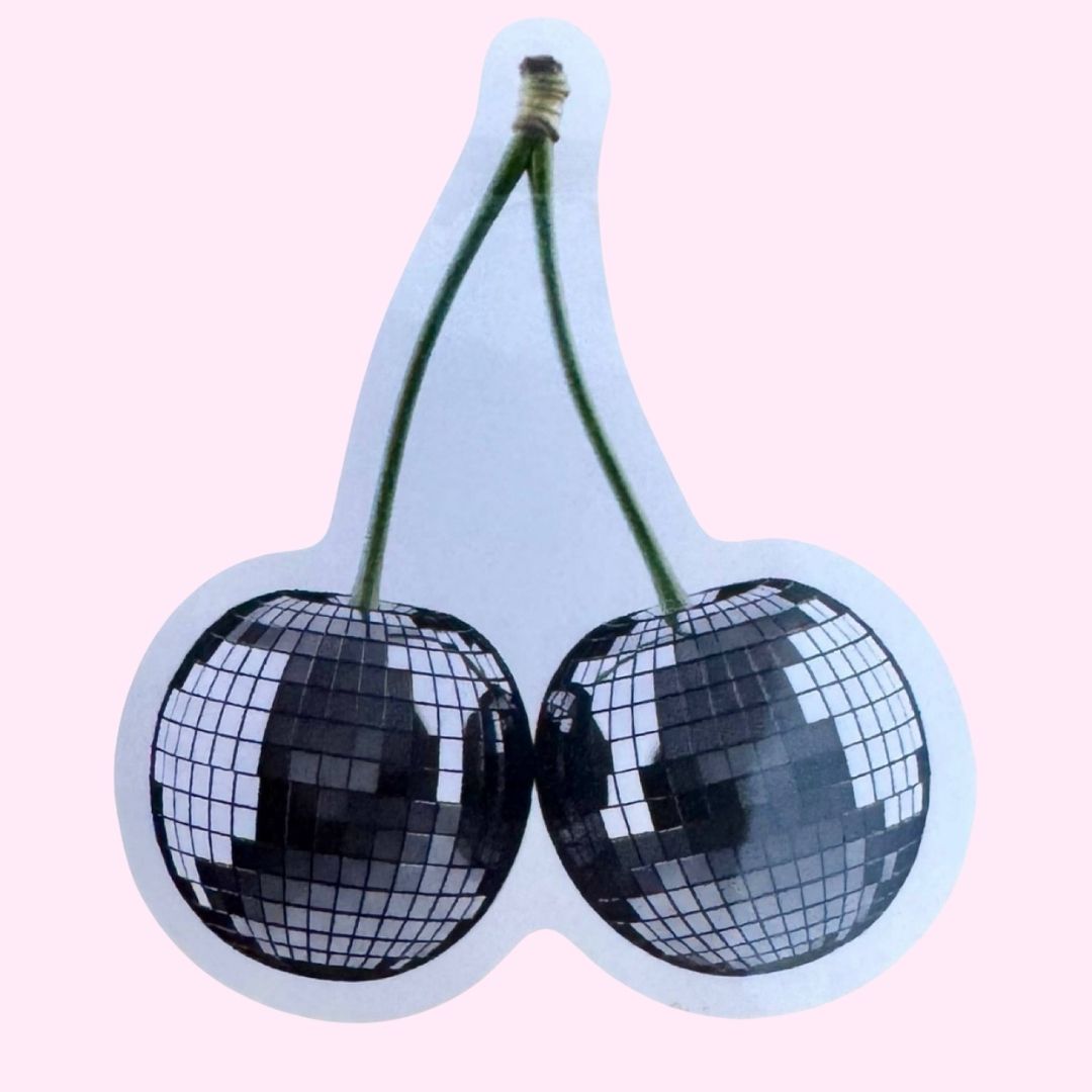 A waterproof vinyl sticker of a pair of cherries with disco balls instead of berries, on a pink background.