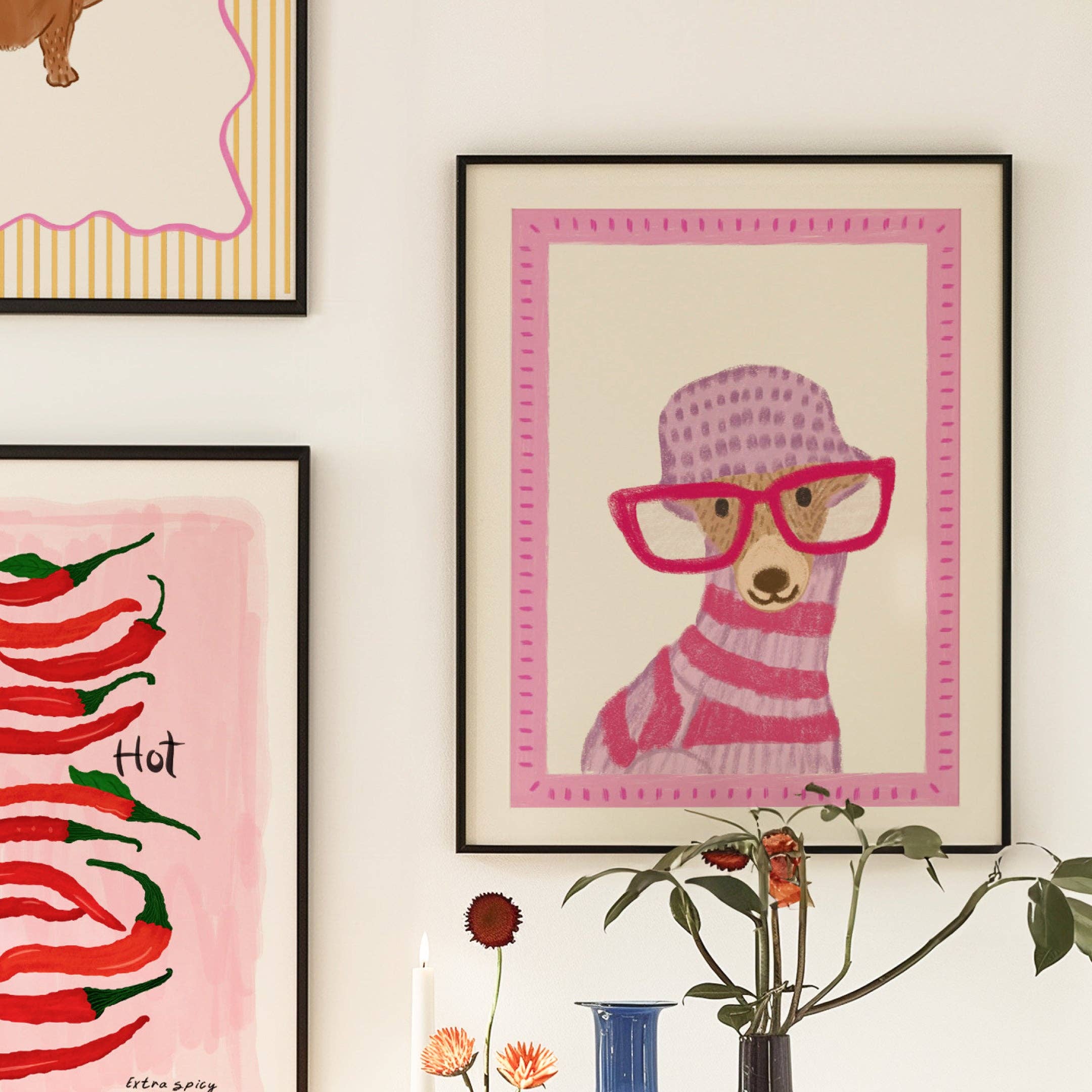 Framed artwork of a dog wearing glasses and a hat on a wall with other decorative elements.