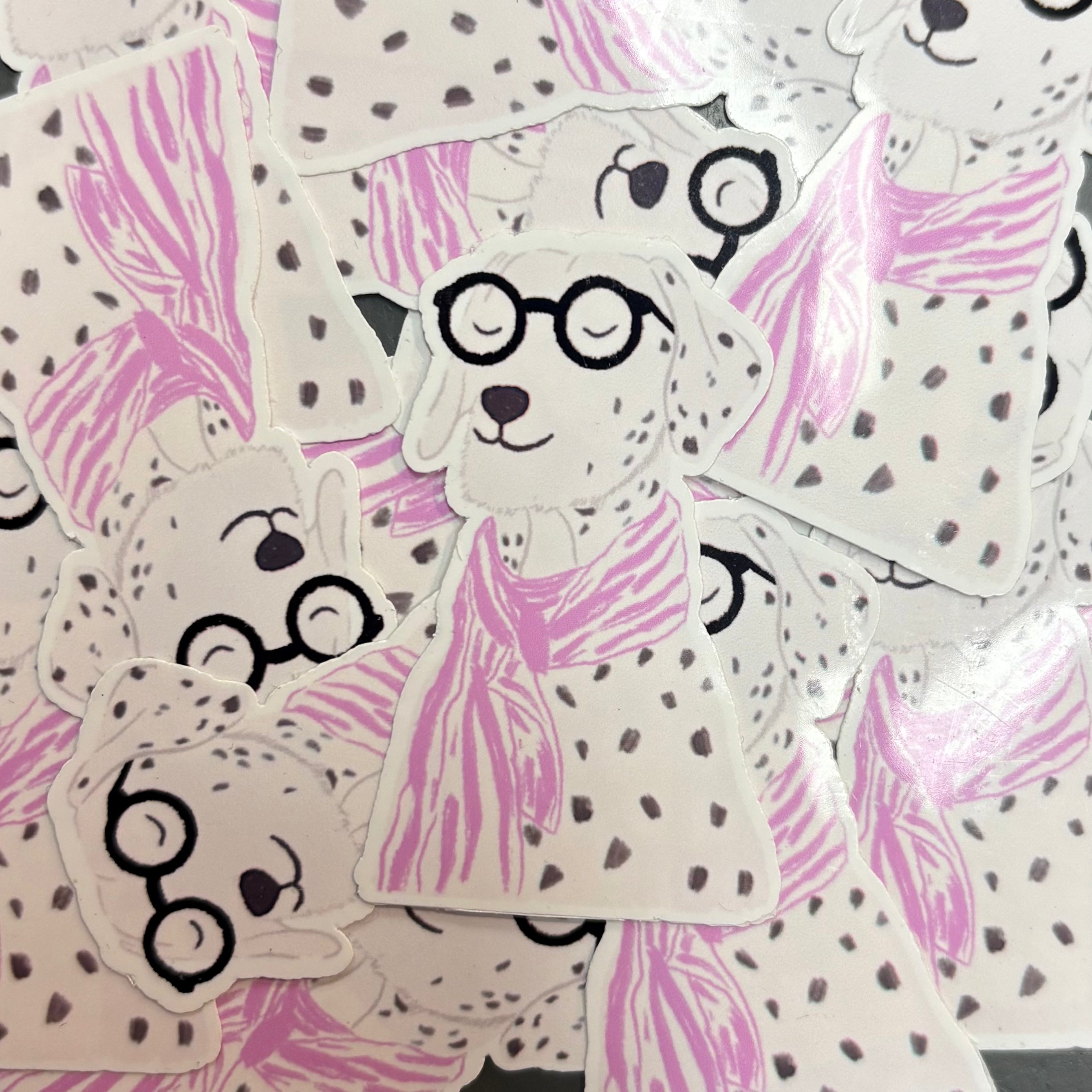 Pile of stickers of a dog with glasses and a pink scarf.