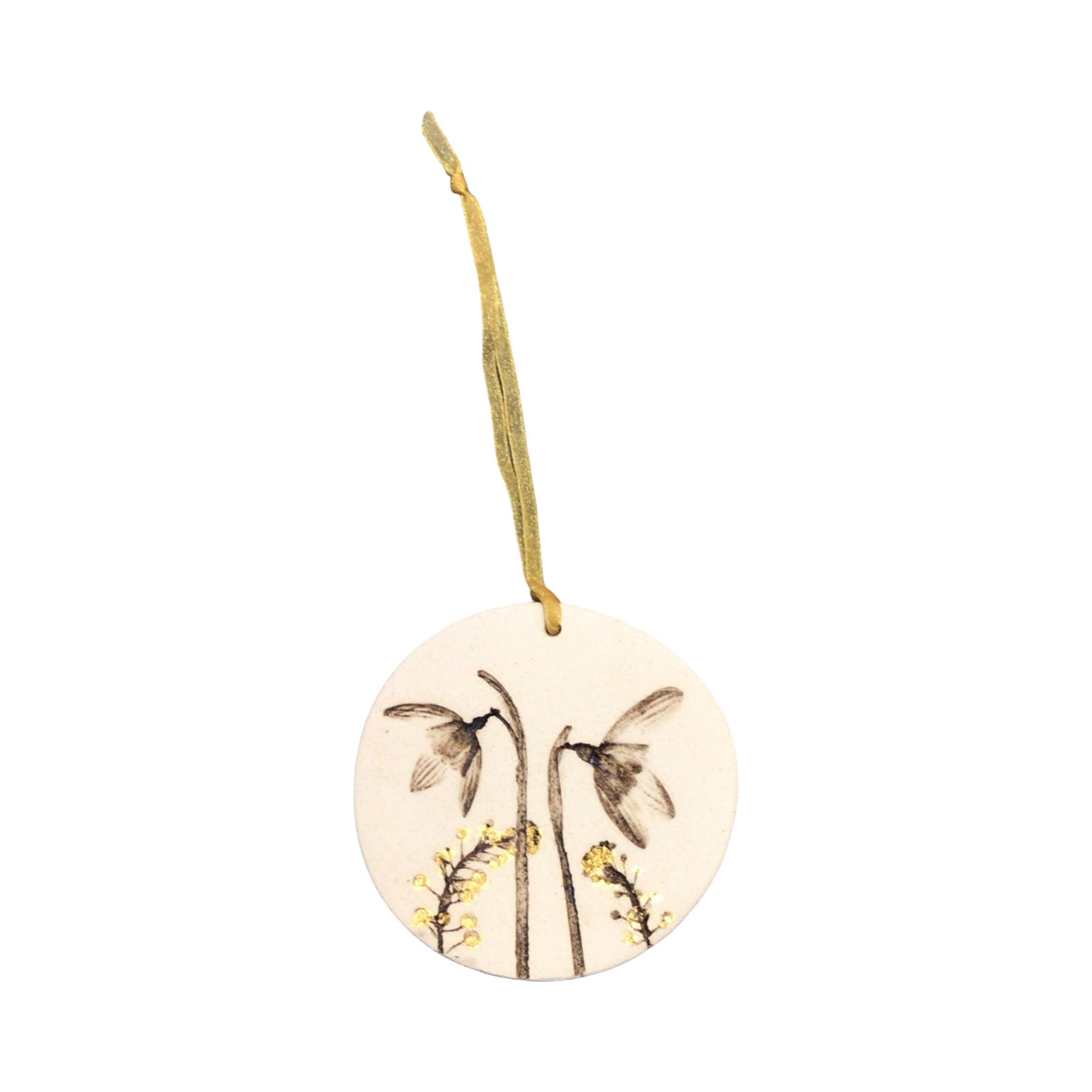 Round ceramic ornament with floral design and gold string on a white background