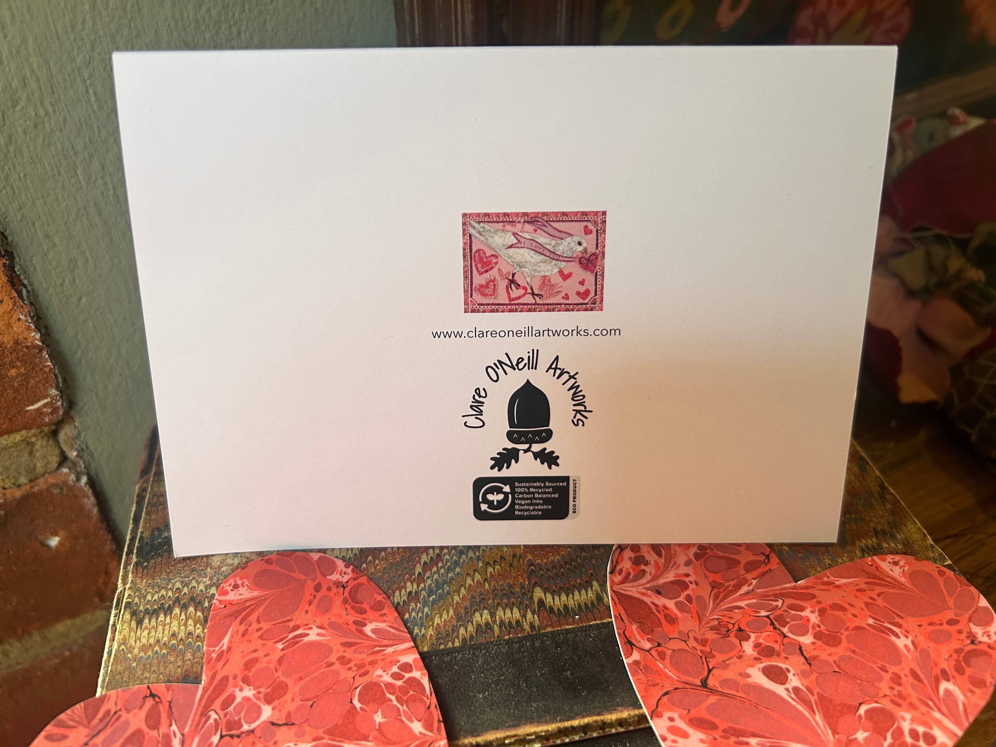 Back of card with Clare O'Neill Artworks branding on a textured surface.