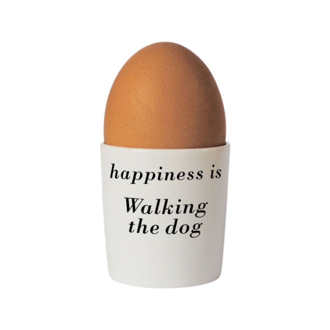 Bone china egg cup with the text 'happiness is walking the dog' written on the back.