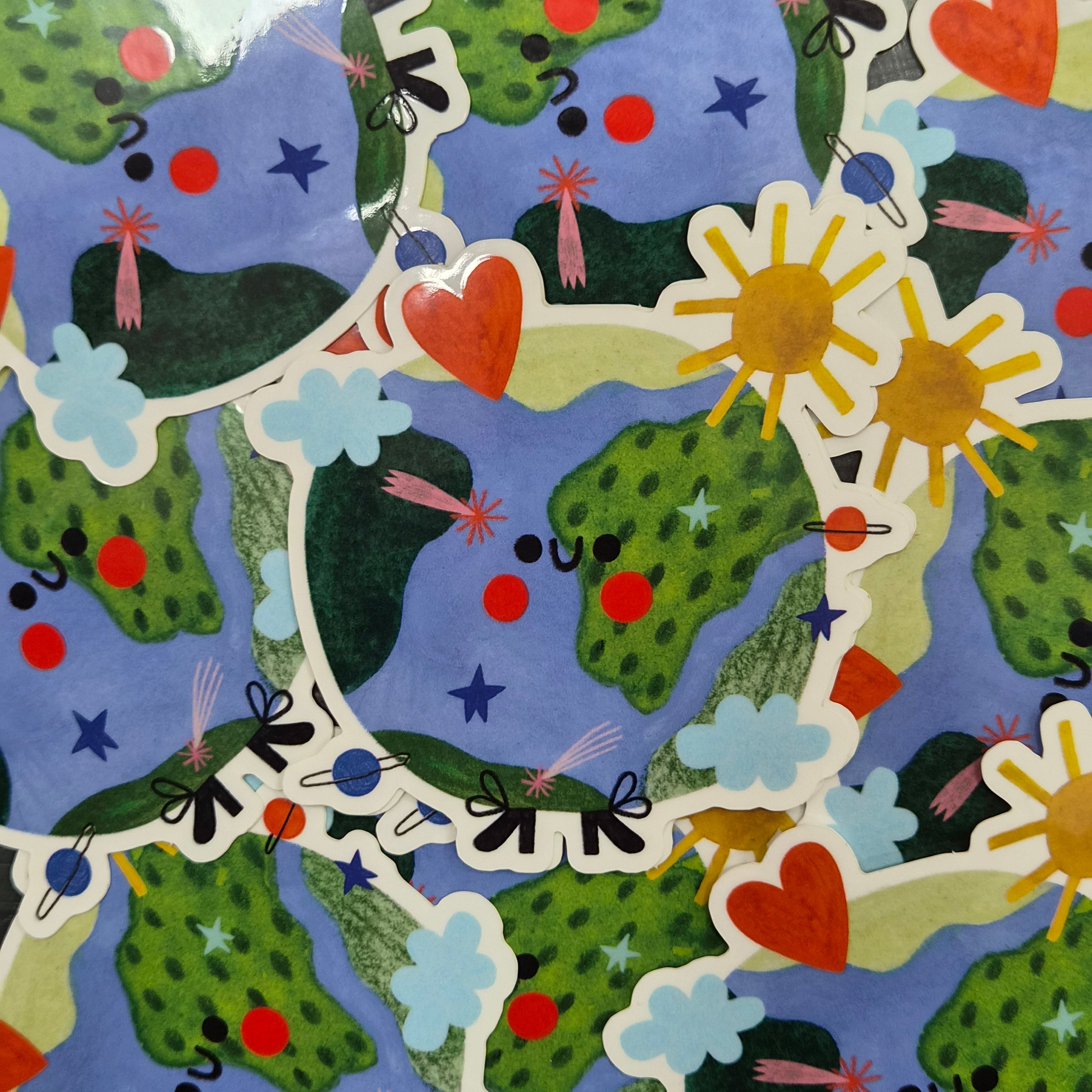 Pile of colourful earth stickers wit a smile, the sun, clouds and a heart.