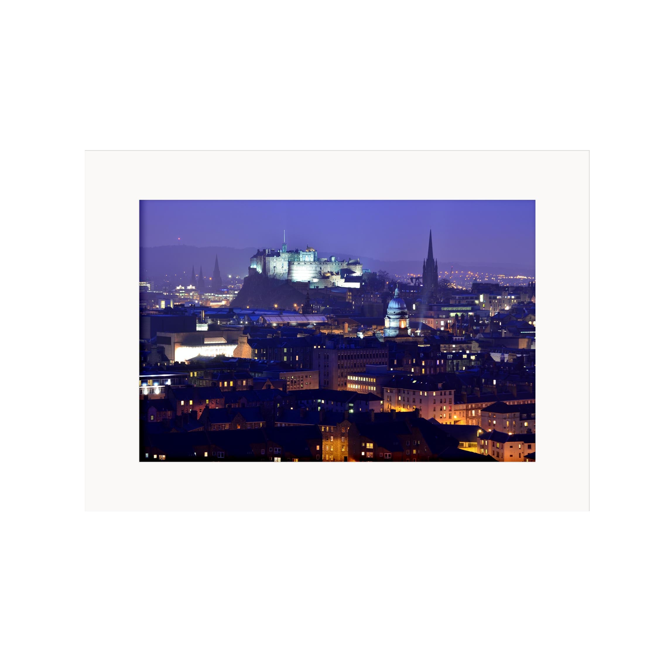 An image of Edinburgh Castle lit up at night in a mount. 