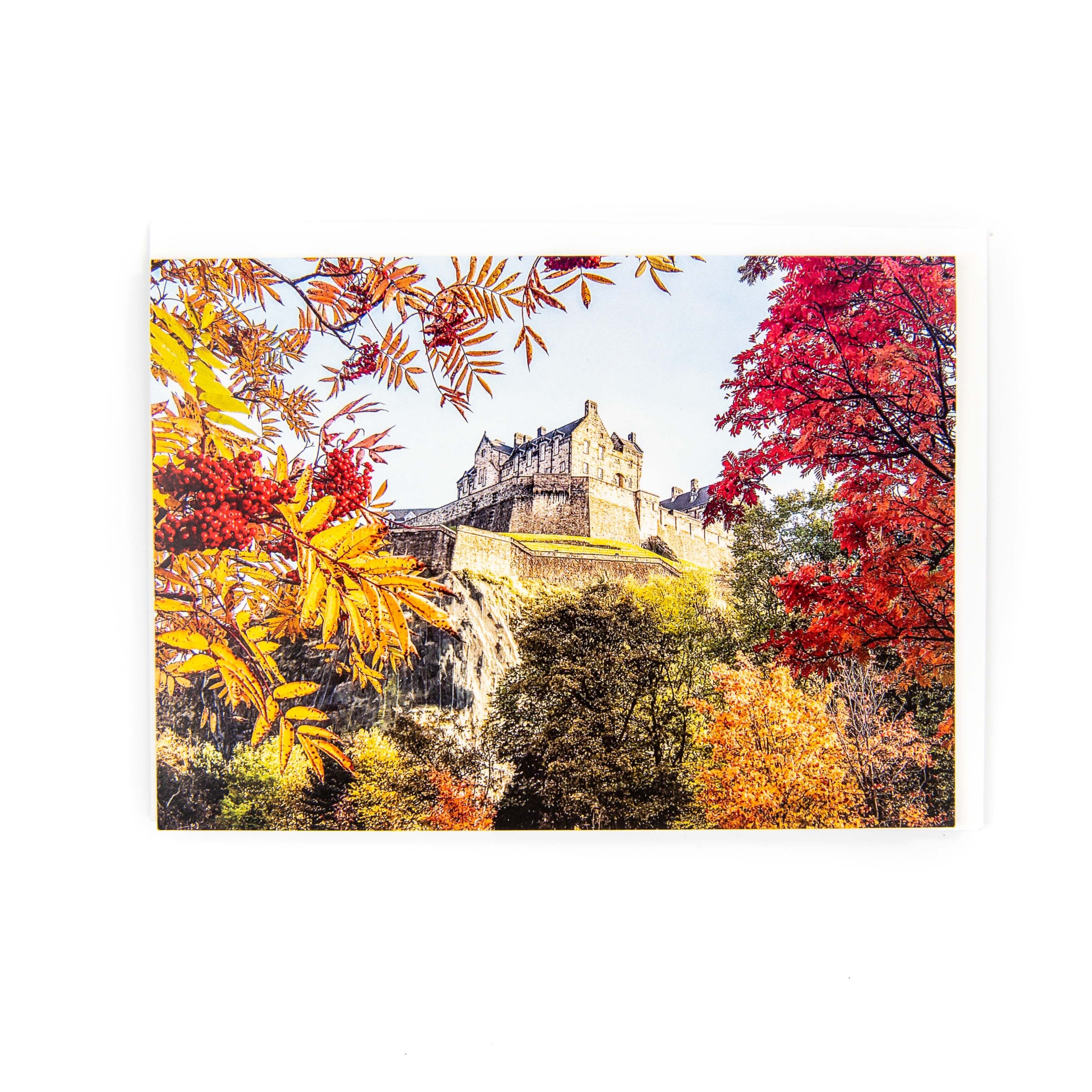 A picture of a card featuring Edinburgh Castle surround by trees in Autumn colours. 