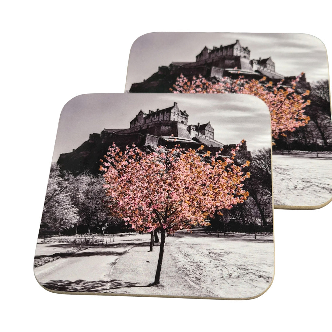 Two coasters with a castle and cherry blossom tree design on a white background