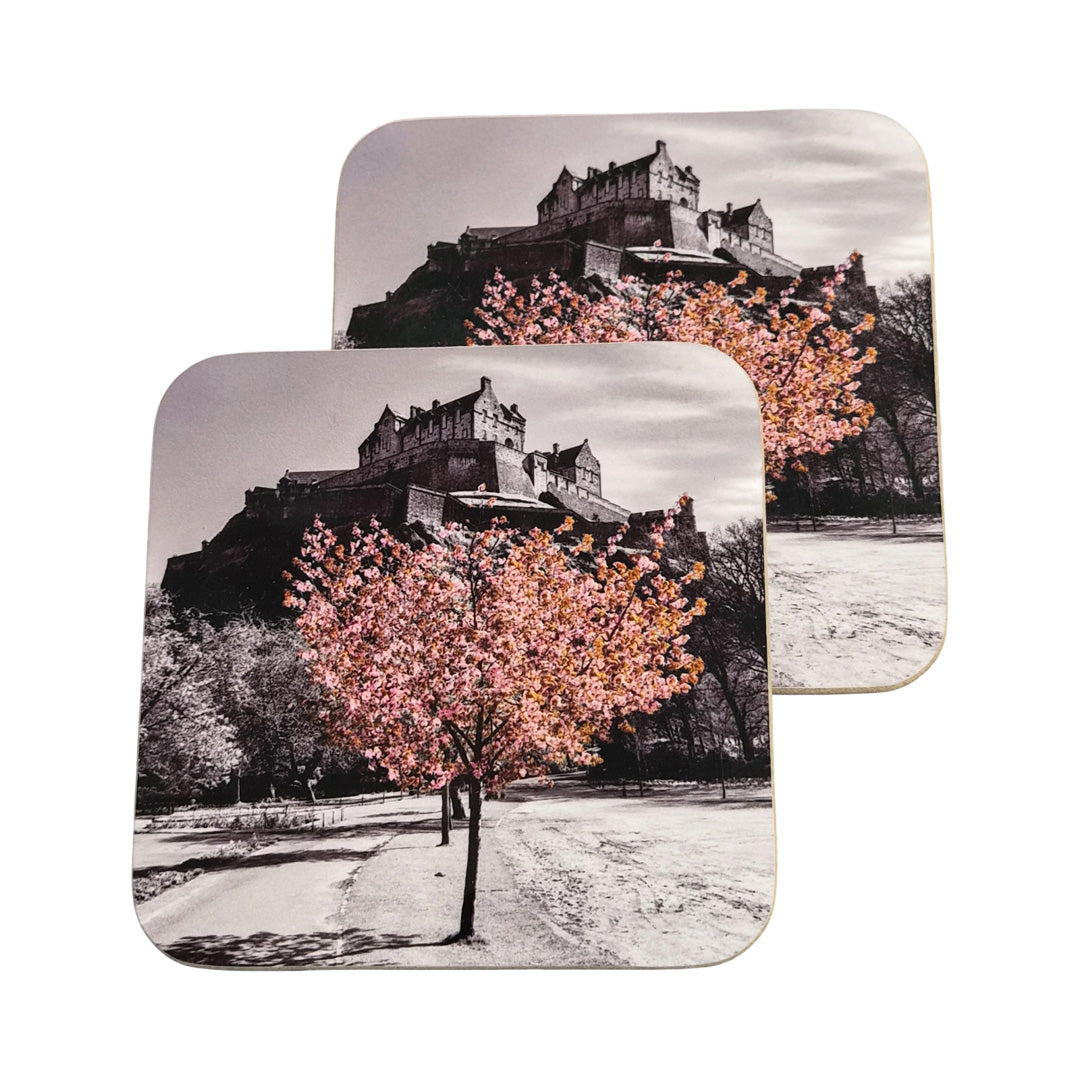 Two coasters with a castle and cherry blossom tree design on a white background