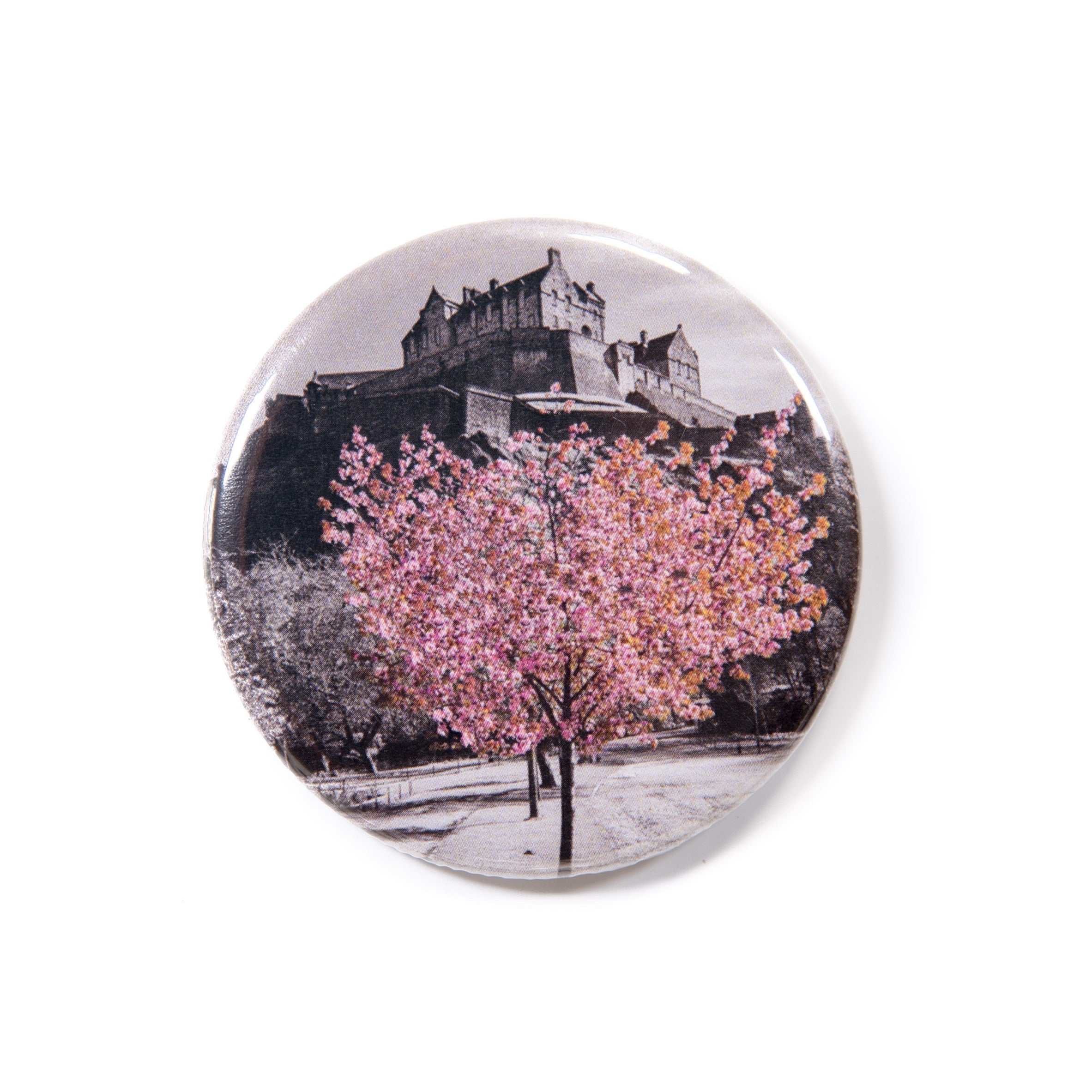 A round fridge magnet featuring a photograph of cherry blossoms under Edinburgh Castle.