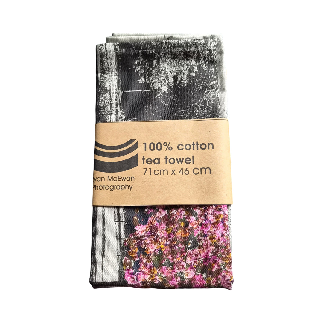Tea towel with floral design and text on a white background