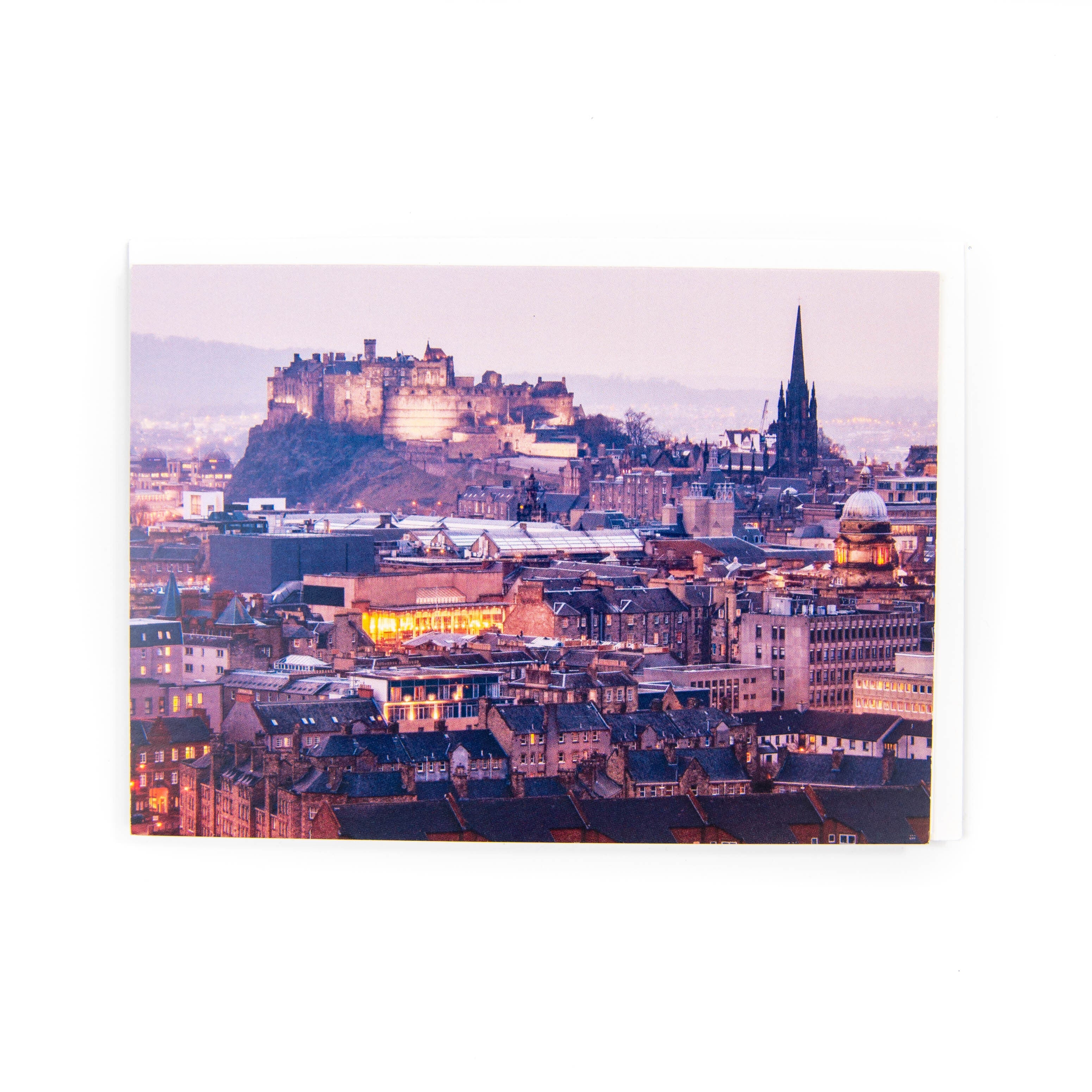 A greeting card featuring a photograph of Edinburgh Castle at dusk. The card is blank inside and includes a white envelope.