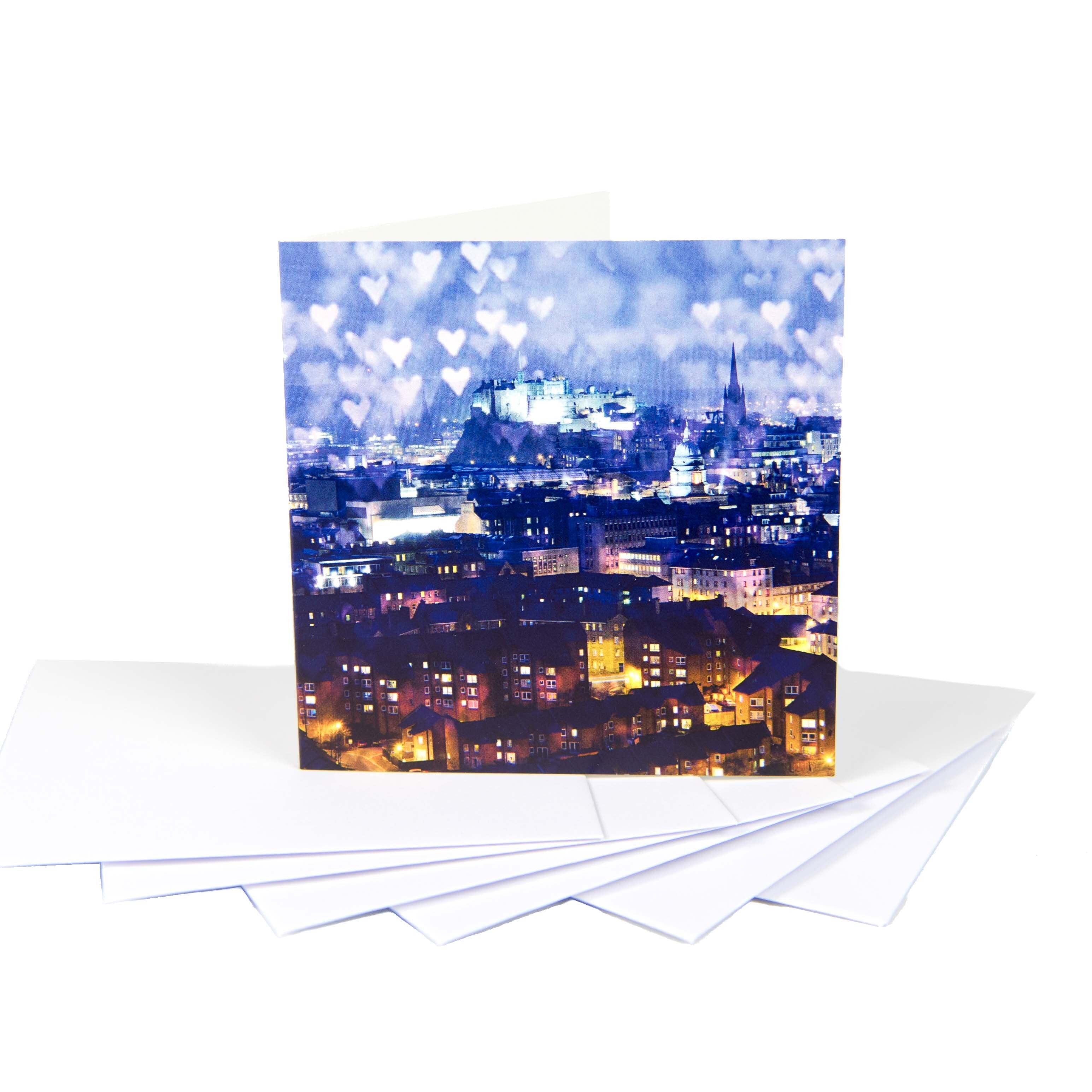A small square card with a scene of Edinburgh Castle, sat on a stack of white envelopes.