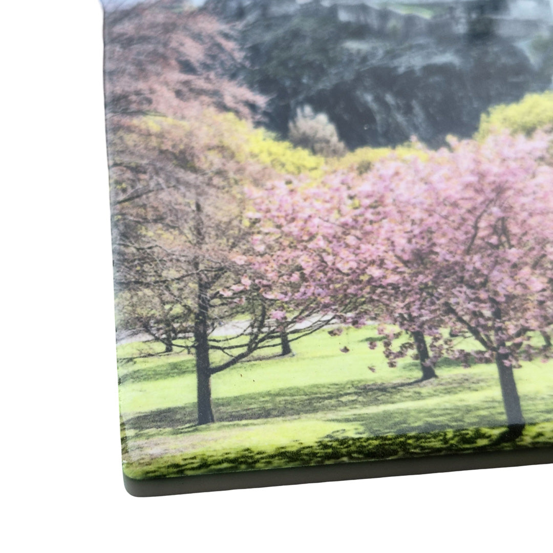A close up of a ceramic coaster featuring Princes Street Gardens. 
