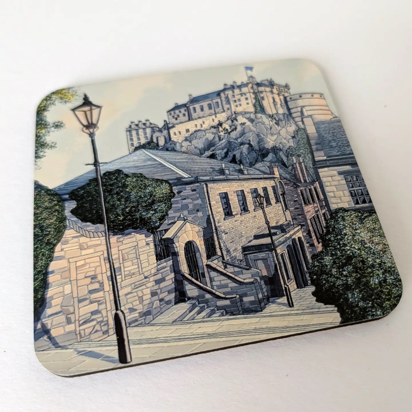 Coaster with a scenic illustration of Edinburgh castle on a white background.
