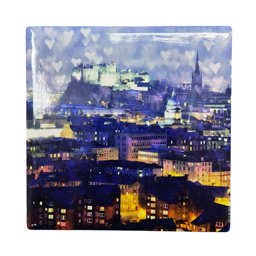 Cityscape with illuminated buildings and a prominent castle-like structure at night.