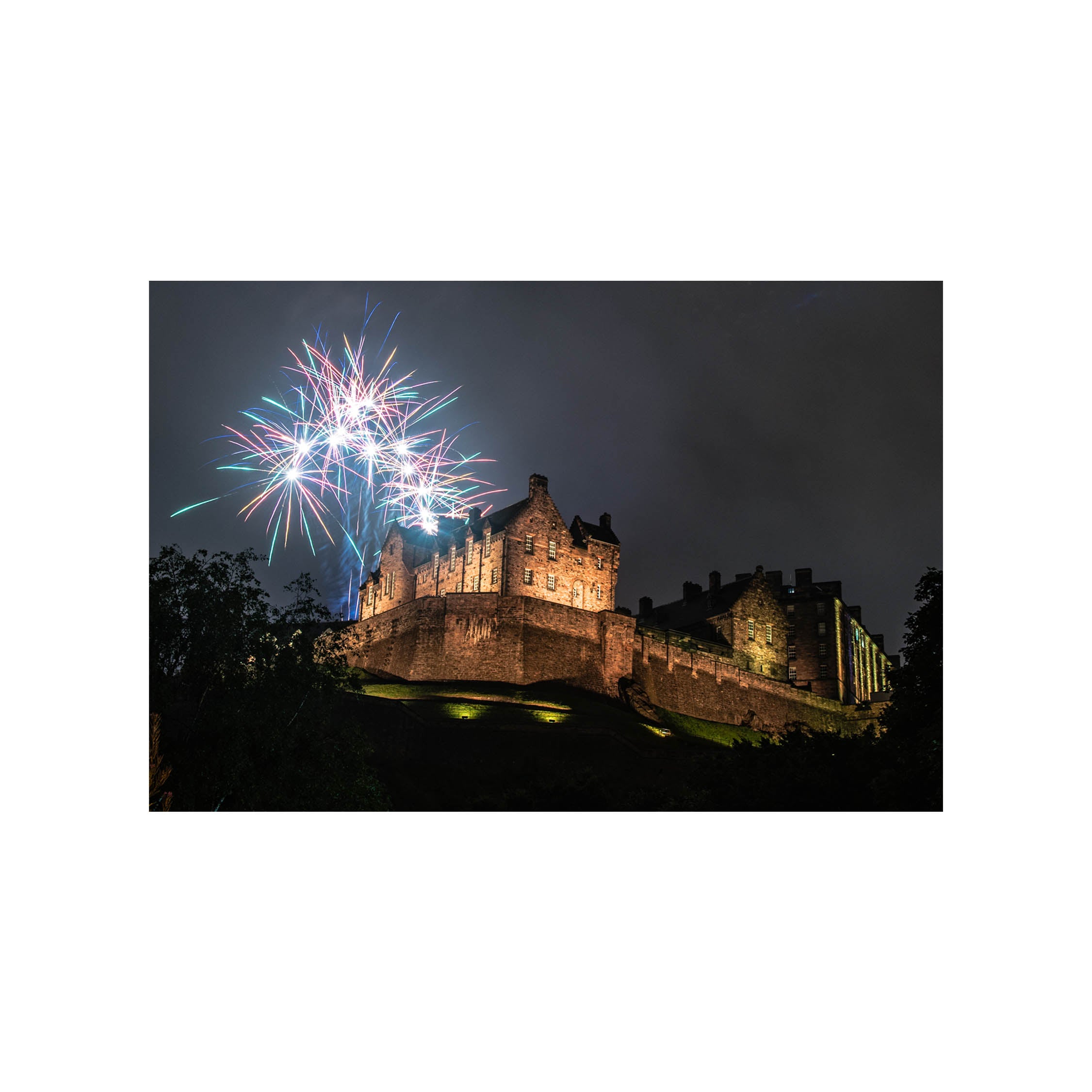 An image of Edinburgh Castle with fireworks above it taken at night. 
