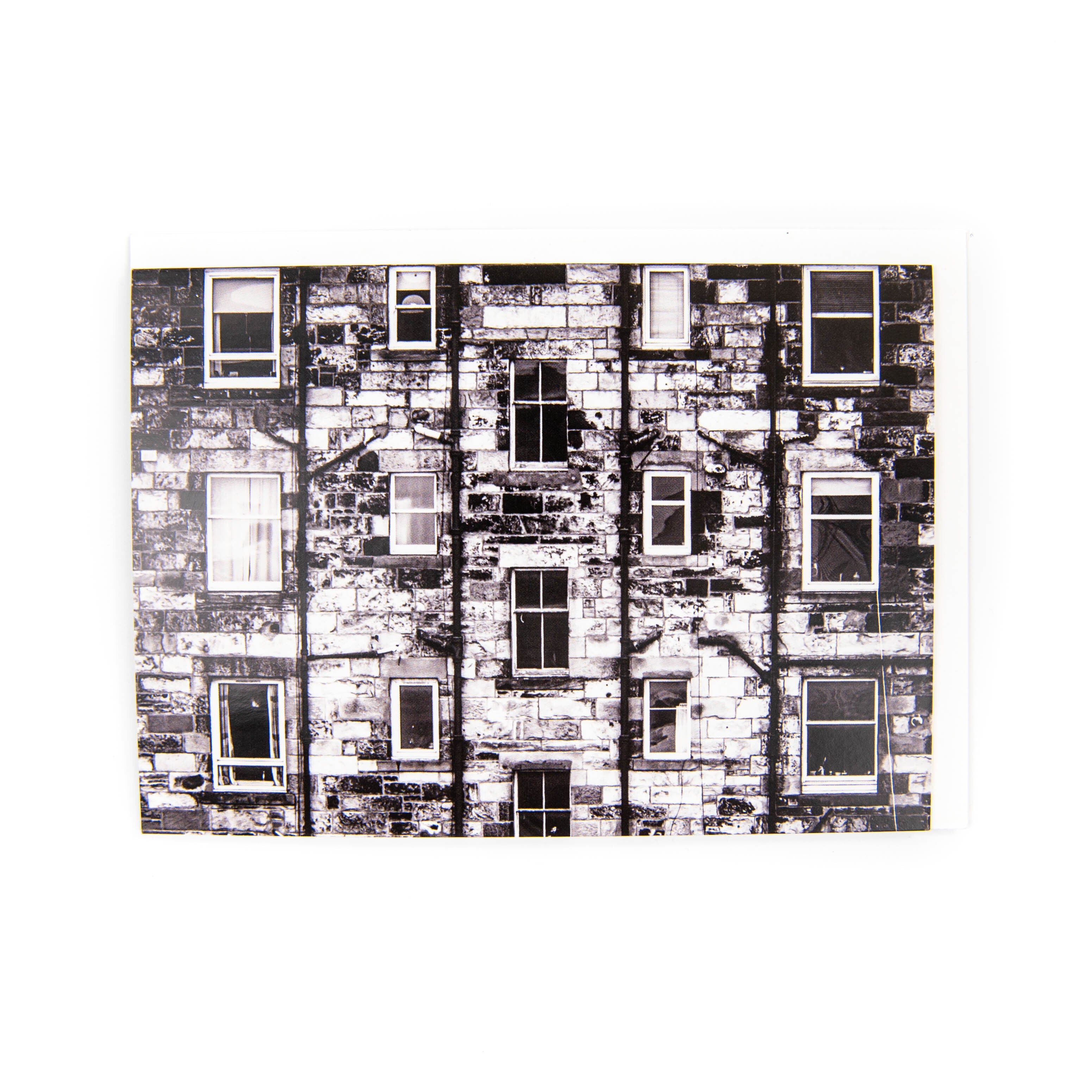 A black and white photograph of a tenement building on a greeting card.