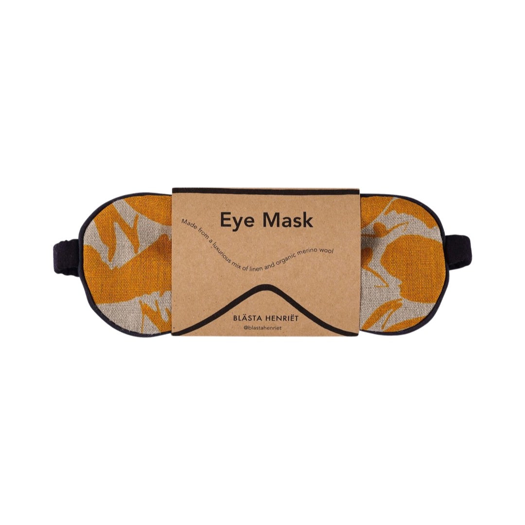 A mustard and cream patterned linen eye mask.