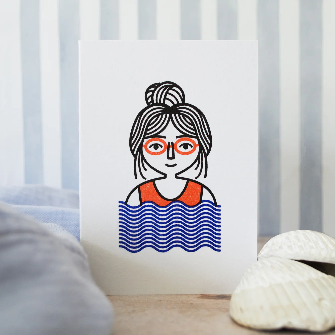 Illustration of a woman with glasses and a swimsuit, standing in water, on a striped background, in sand next to shells.
