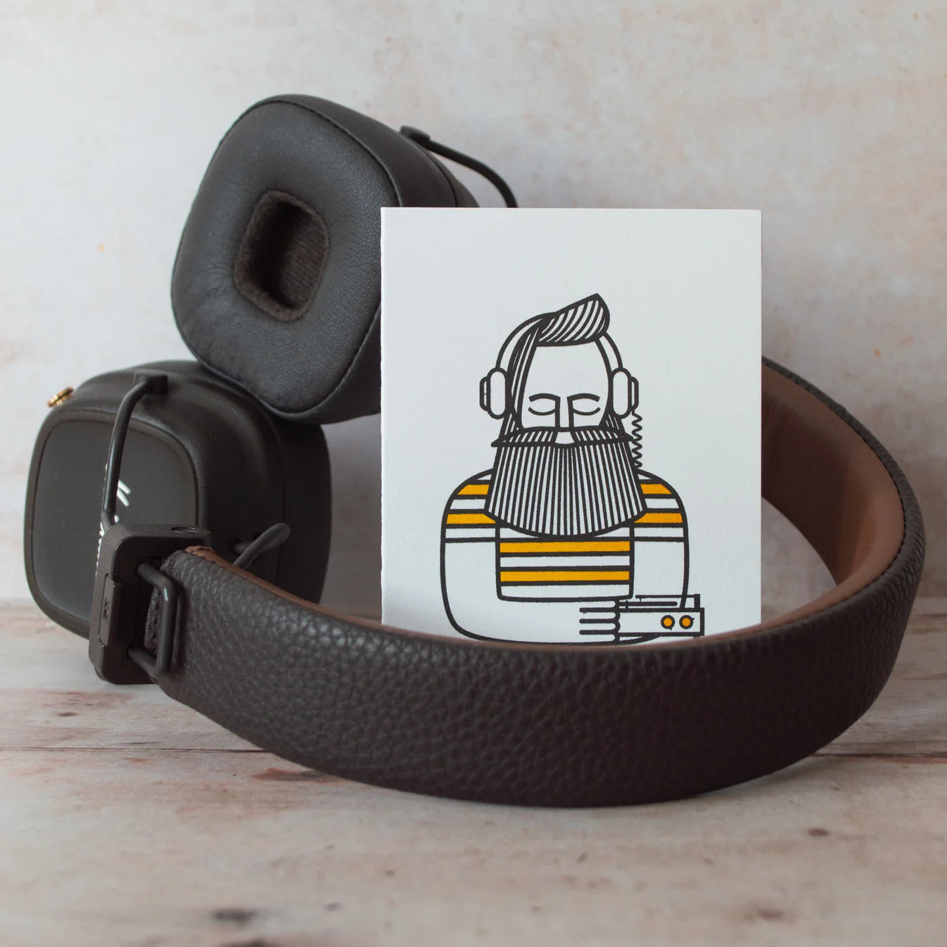 Illustration of a man listening to music, on a wooden background sat inside a pair of headphones.
