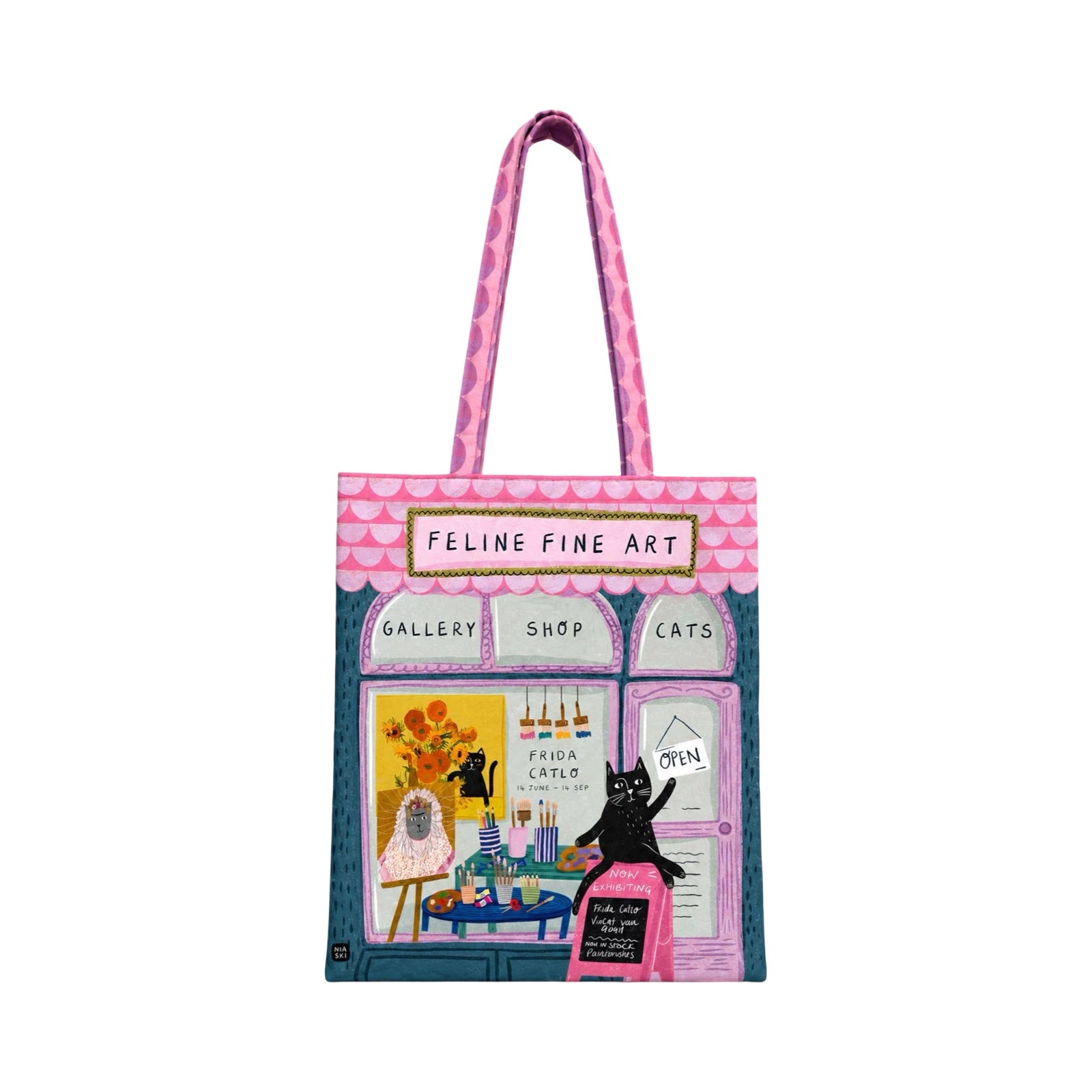 A tote bag featuring a whimsical illustration of a cat-themed art gallery storefront with pink handles and a colourful printed design.