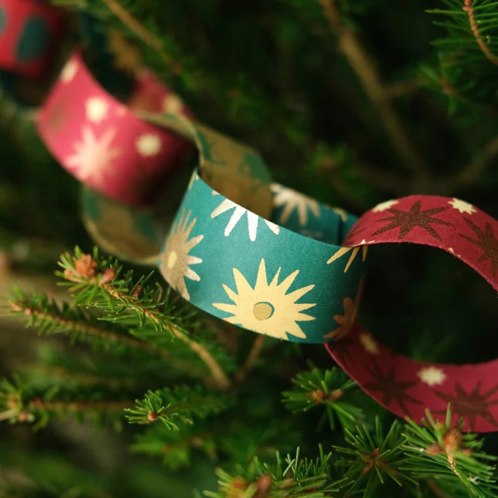 Decorative paper chain with red and green patterns on a Christmas tree.